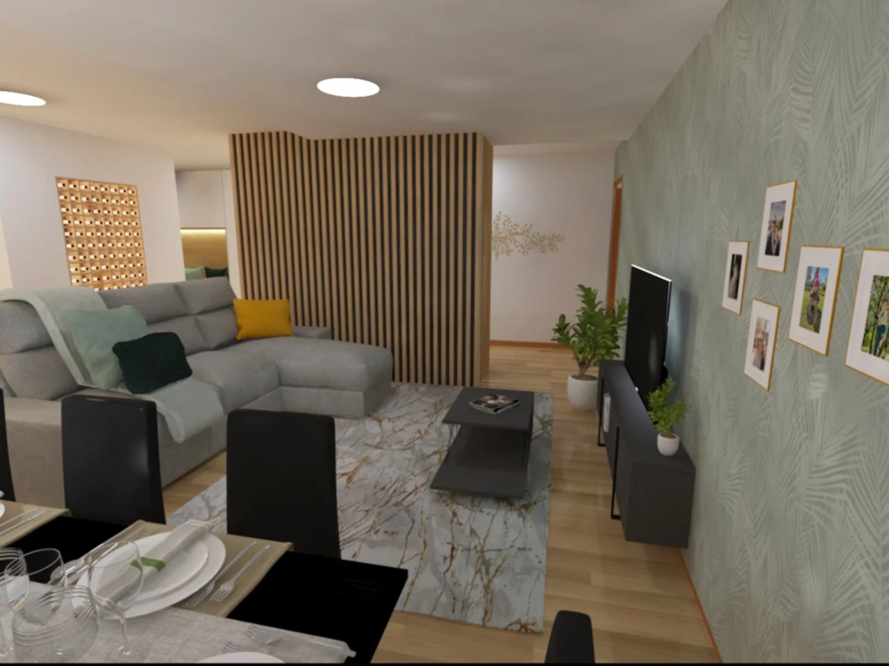 Sala de estar com sofá cinza, televisão, plantas e parede decorada com fotos emolduradas.