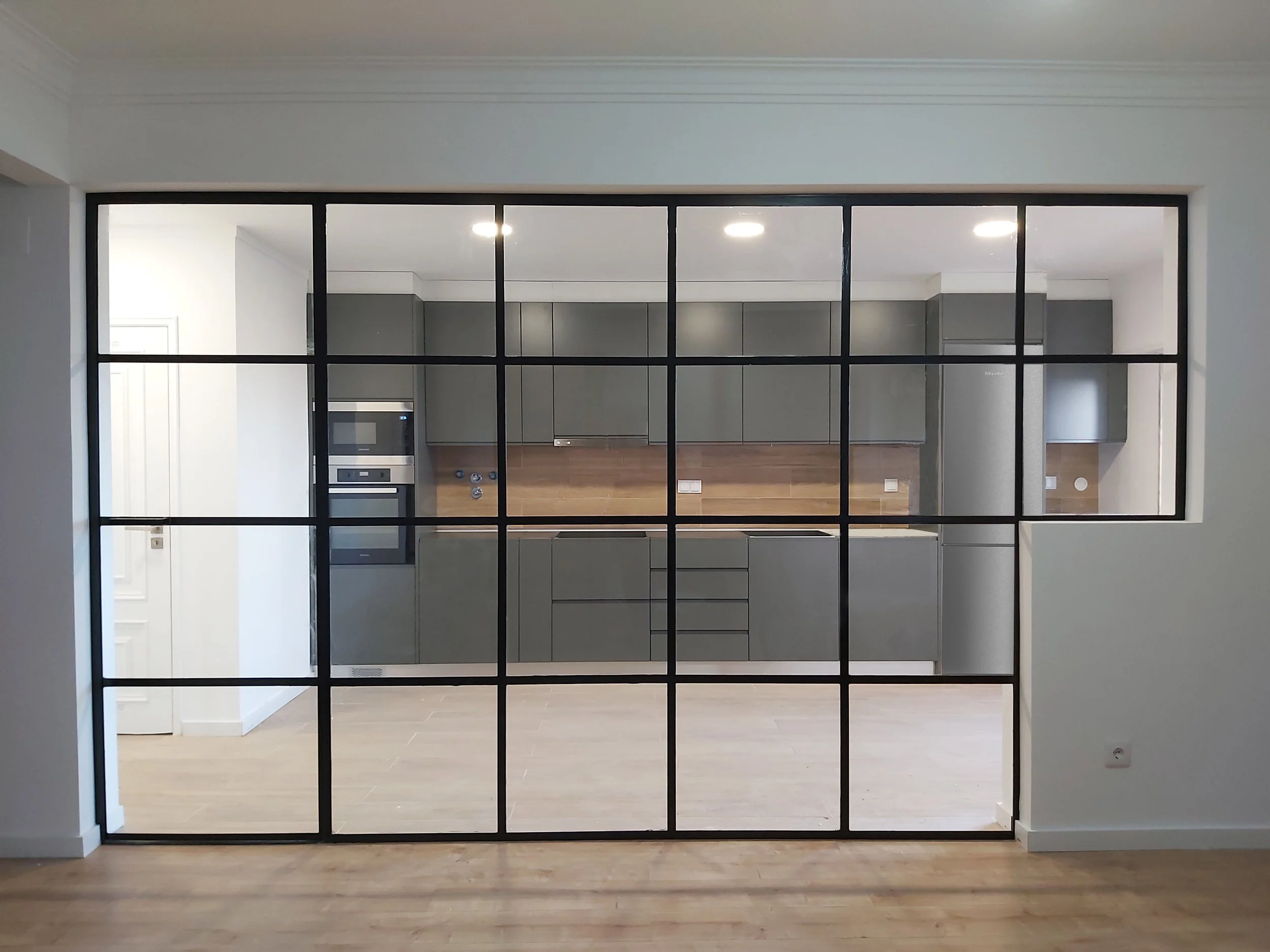 Divisória em metal com porta oculta, estilo industrial, para separação entre sala e cozinha, em apartamento na Quinta Grande,  Alfragide