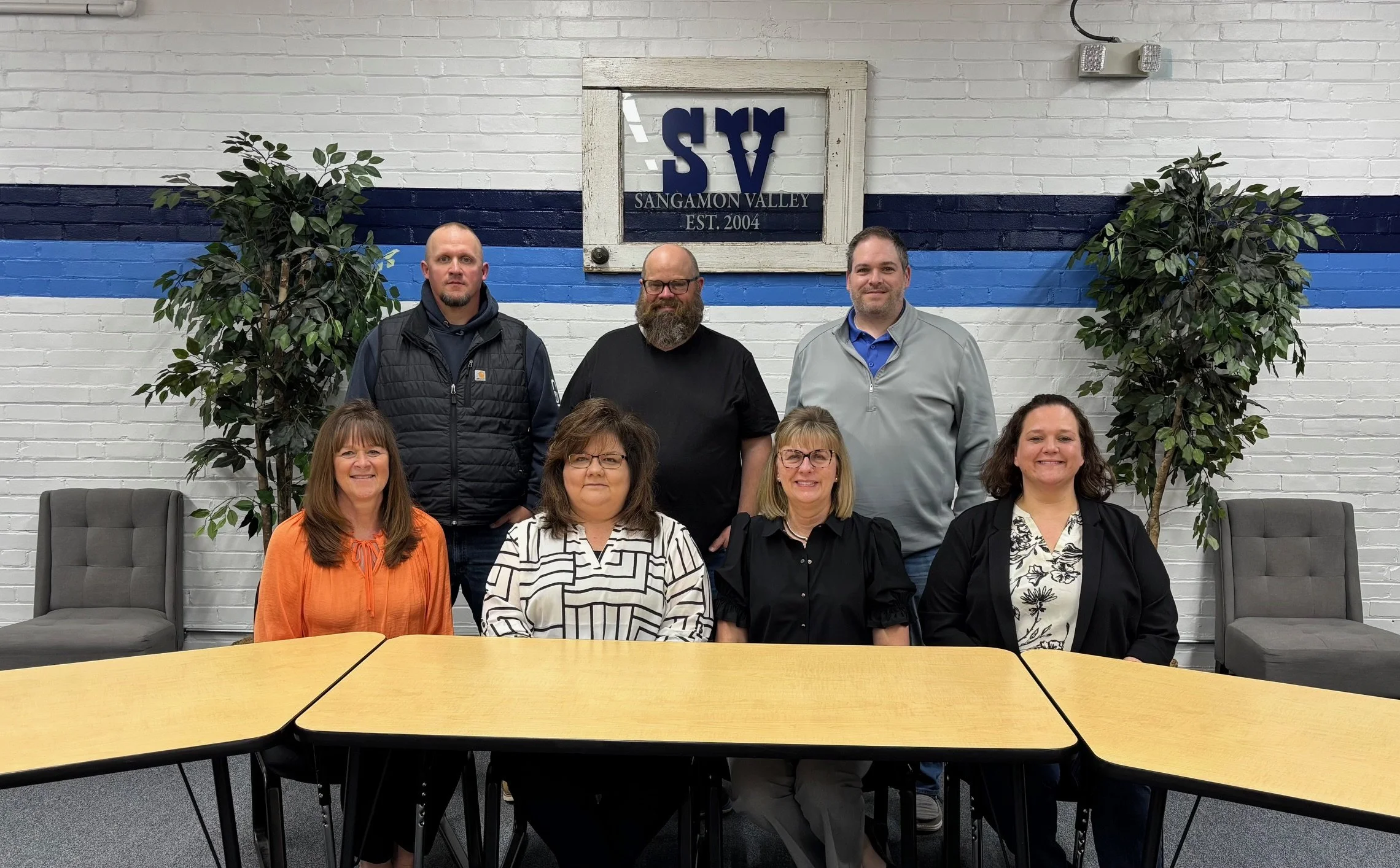 CUSD #9 school board members pose around a table in the library.