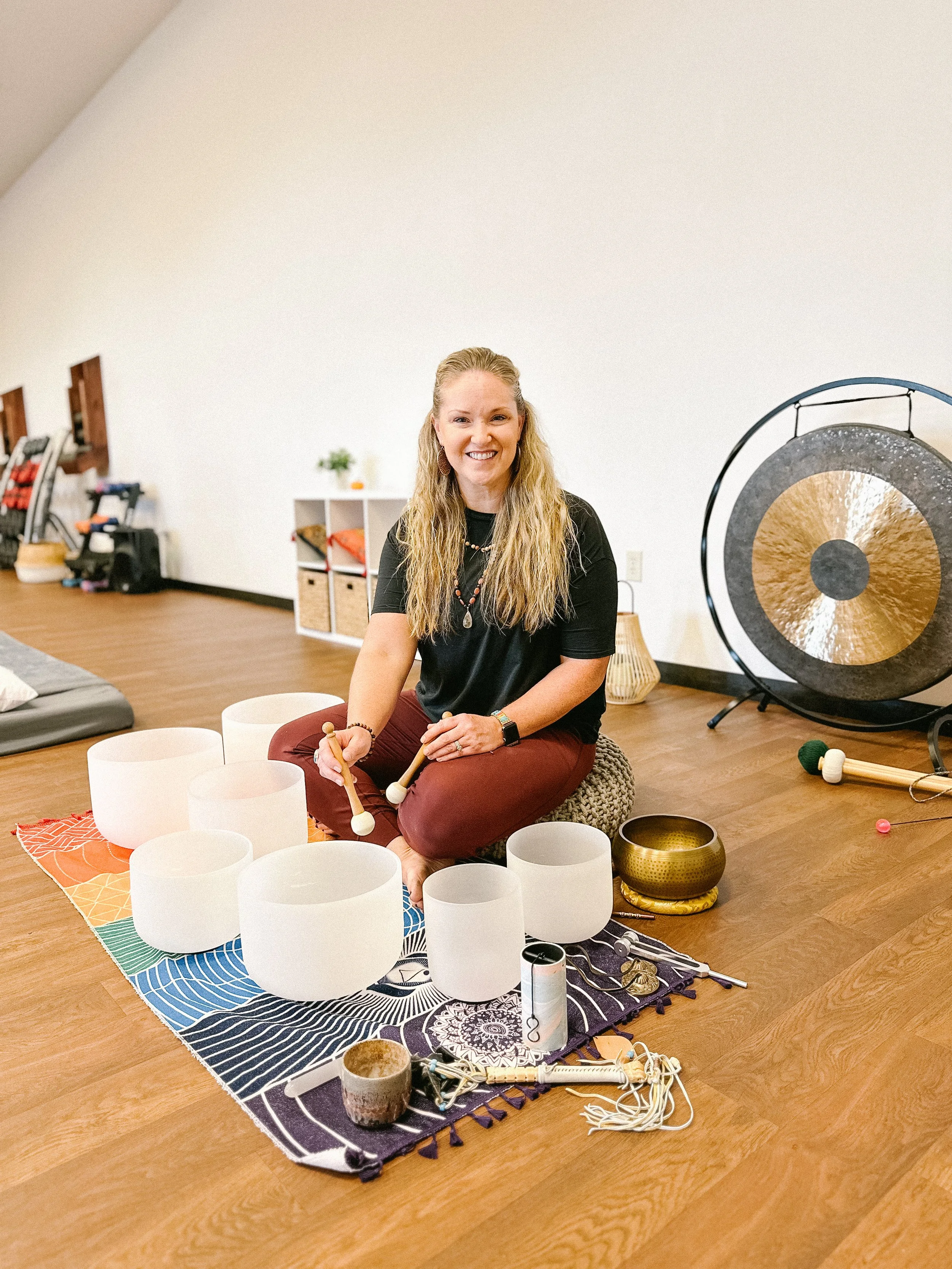 Sandy Orsund using sound healing bowls to help clients with recovery at The Union, Wellness Boutique