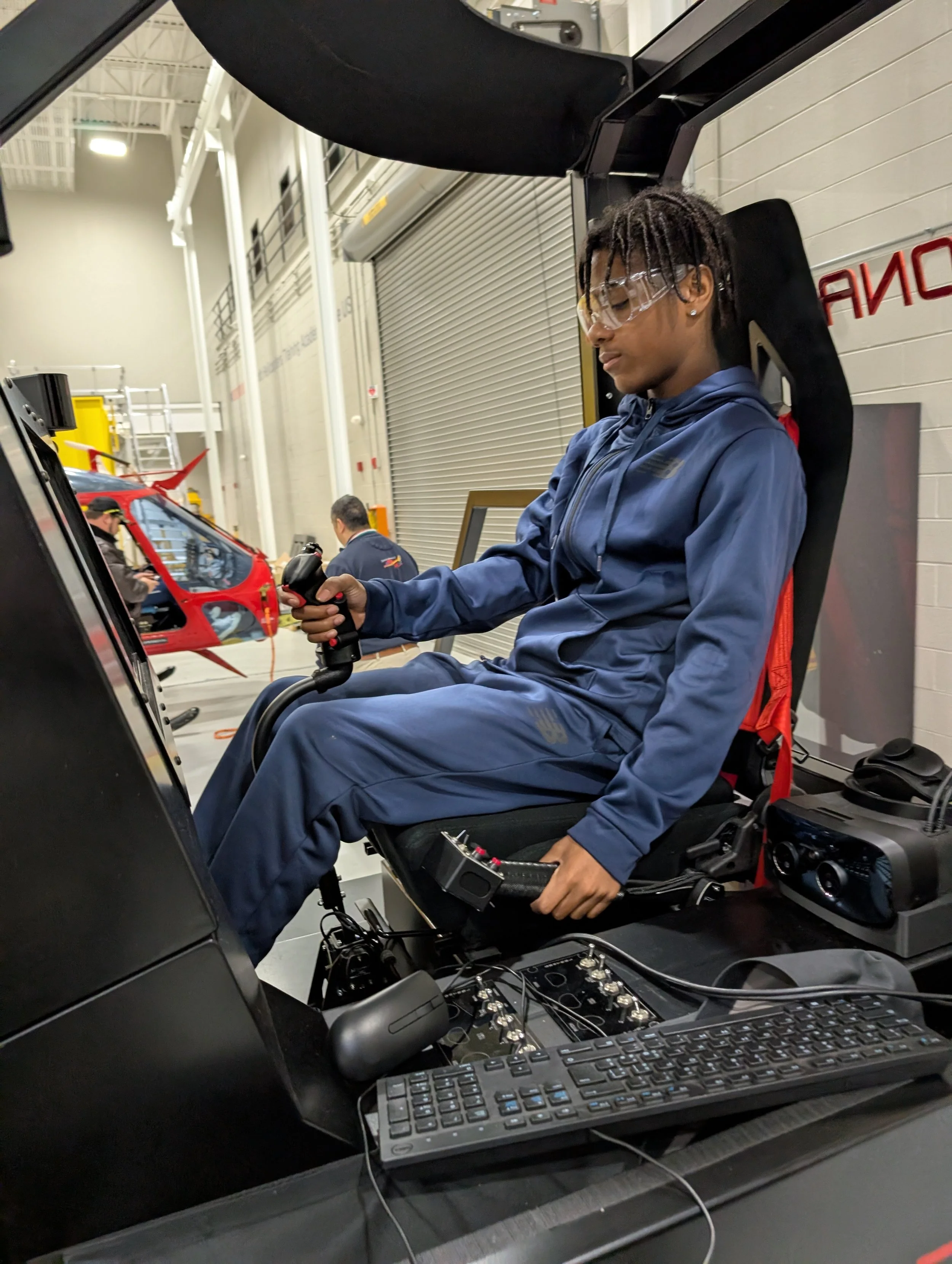 A KB foundation mentee sits in a flight simulator at Leonardo Helicopter.