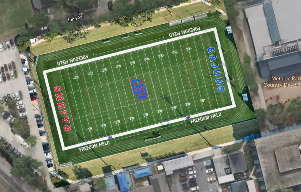Aerial view of a football field named 'Freedom Field' with the team names 'Cajuns' and 'Gauchos' on either side, surrounded by parking lots, buildings, and trees.