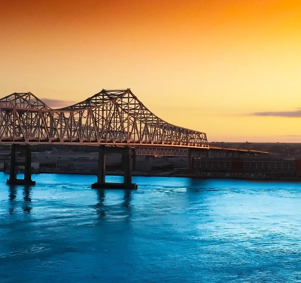 A bridge over a body of water at sunset with a clear sky in the background.