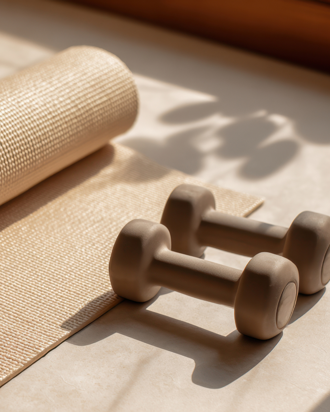 Tan dumbbells and yoga mat