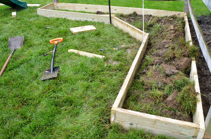 wood boards being attached together for the corner raised bed