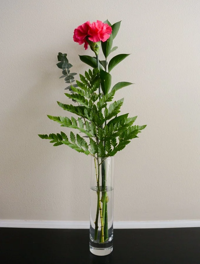 add a pink carnation to the vase