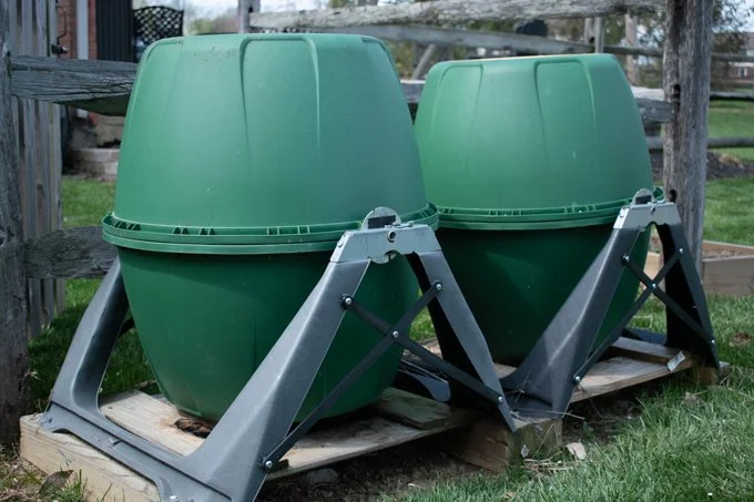 2 miracle-gro compost tumblers sitting in yard