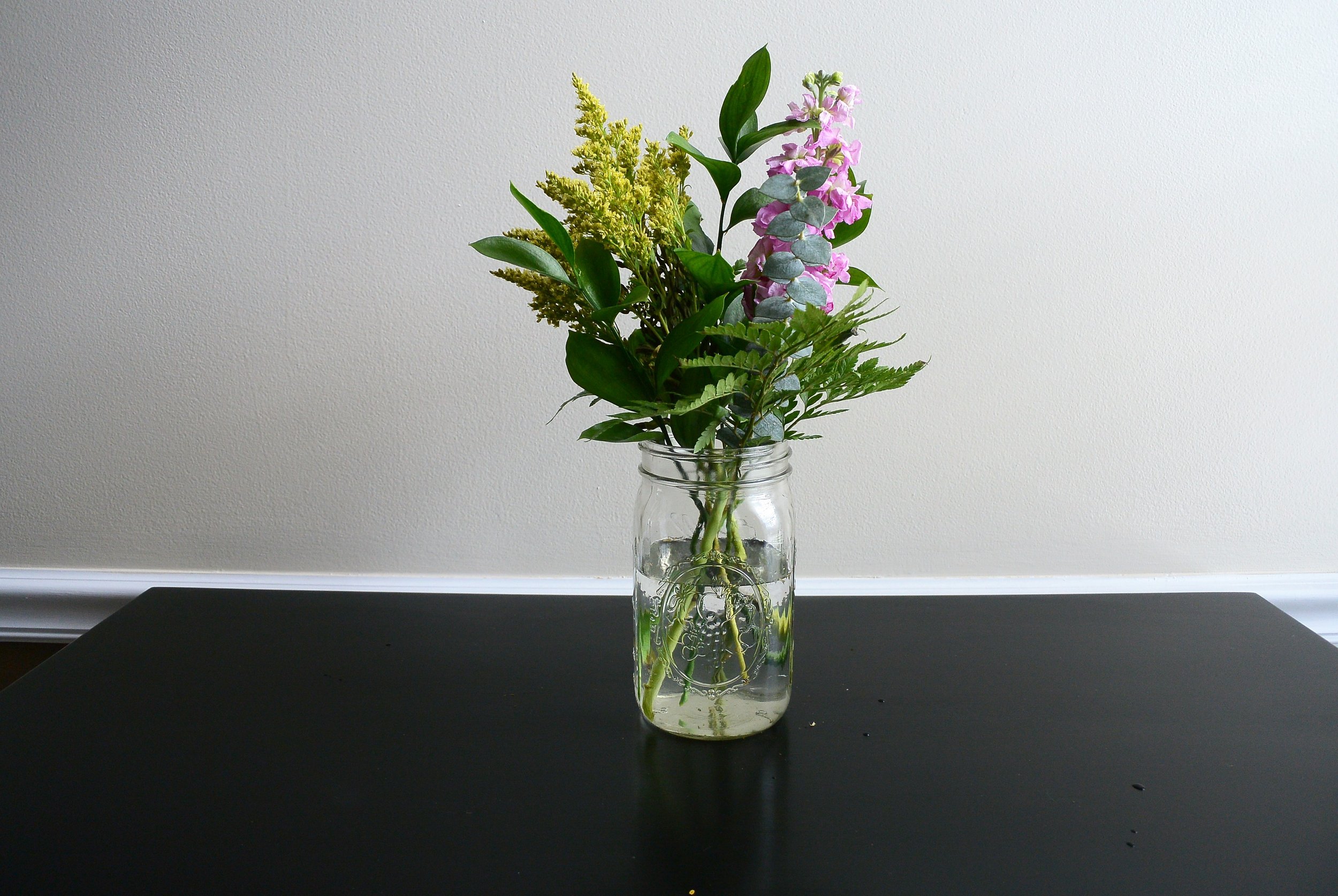 mason jar with greens and solidago and stock