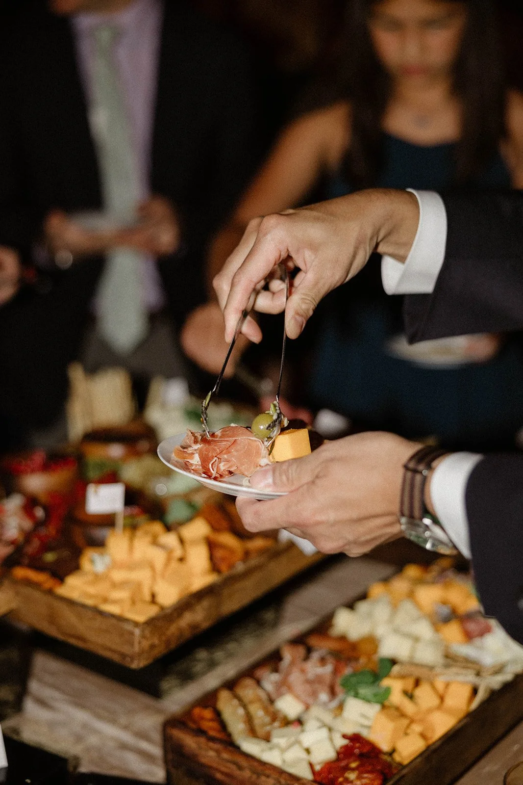 hands serving charcuterie on a small plate at a corporate event in Chicago