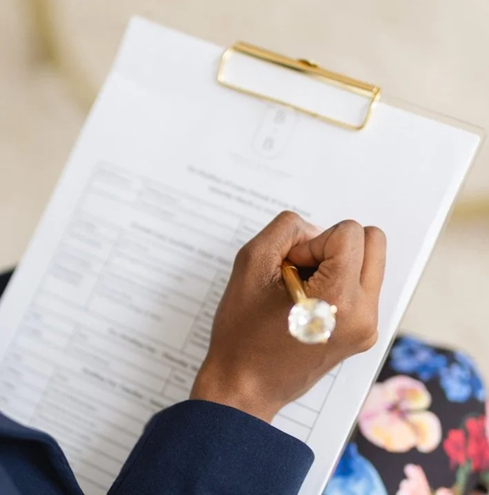 Wedding event timeline on clipboard with hand holding a pen