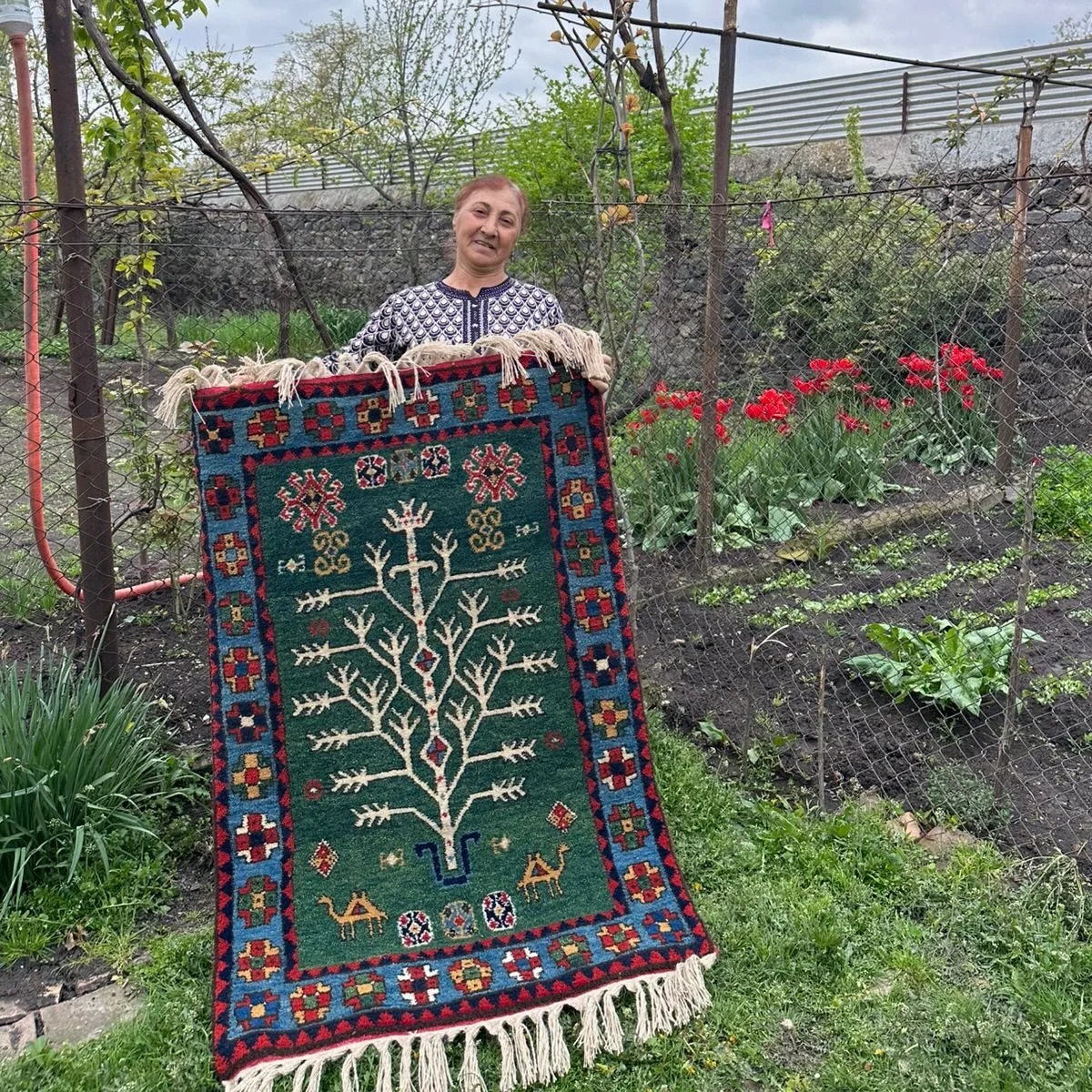 Every year Minaye weaves a green Tree of Life rug on her small loom, here is her 2026 rug, in her garden beside her tulips 🌷🌷🌷 a happy spring from reWoven. available for sale 💌