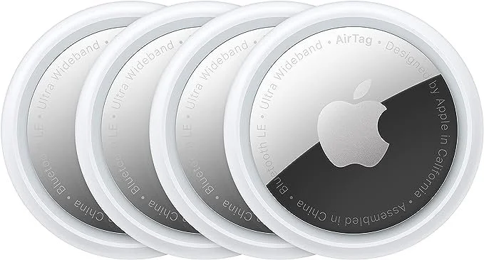 A set of four Apple AirTags with white circular designs and the black Apple logo in the center.