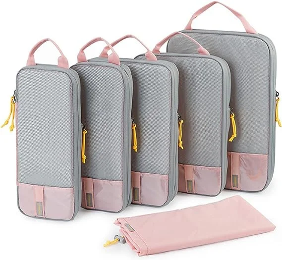 Set of four gray and pink travel organizers with yellow zippers and a pink storage bag, displayed in increasing size order.