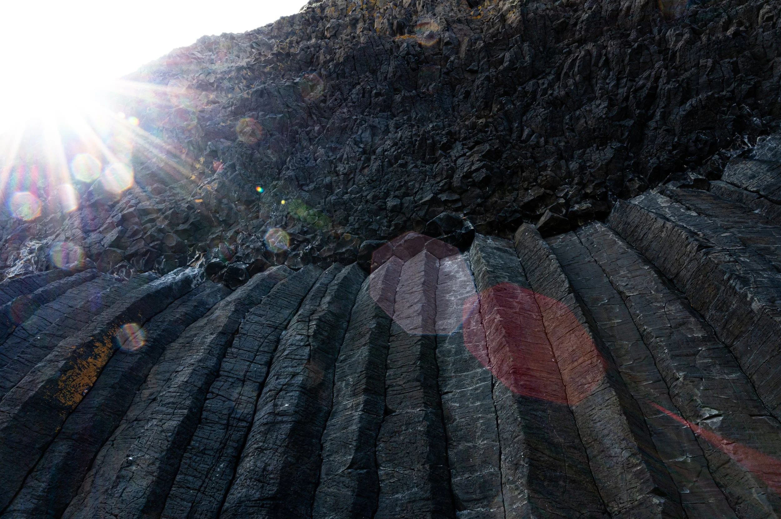 Basaltsäulen mit Sonneneinstrahlung und Lichtreflexionen.