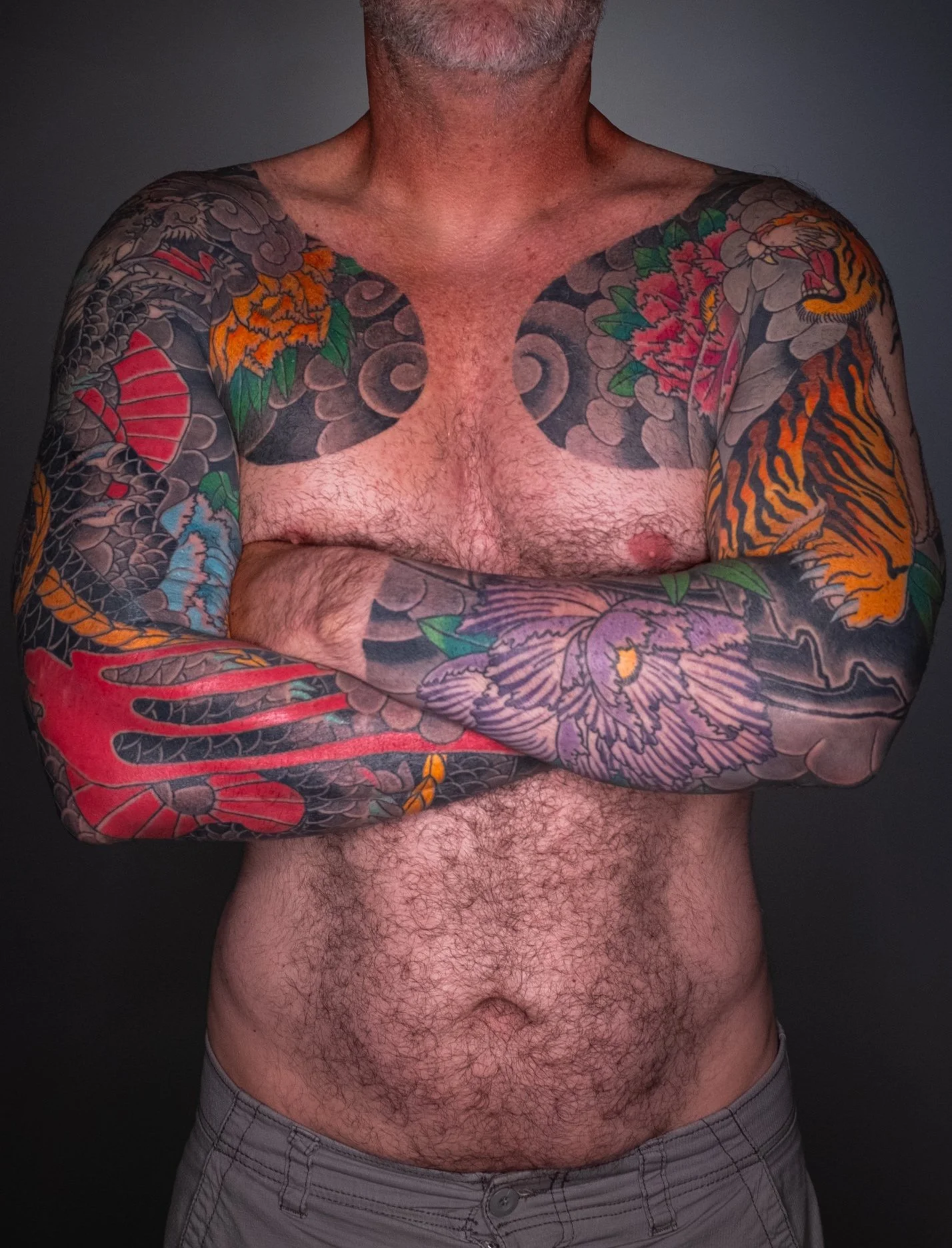 Dragon & Tiger Japanese Sleeve Tattoo — Fort Lauderdale | Full sleeve and chest panel featuring dragon and tiger motifs with peony accents. Black-and-grey outline and background by machine; color applied by hand using tebori. Healed.
