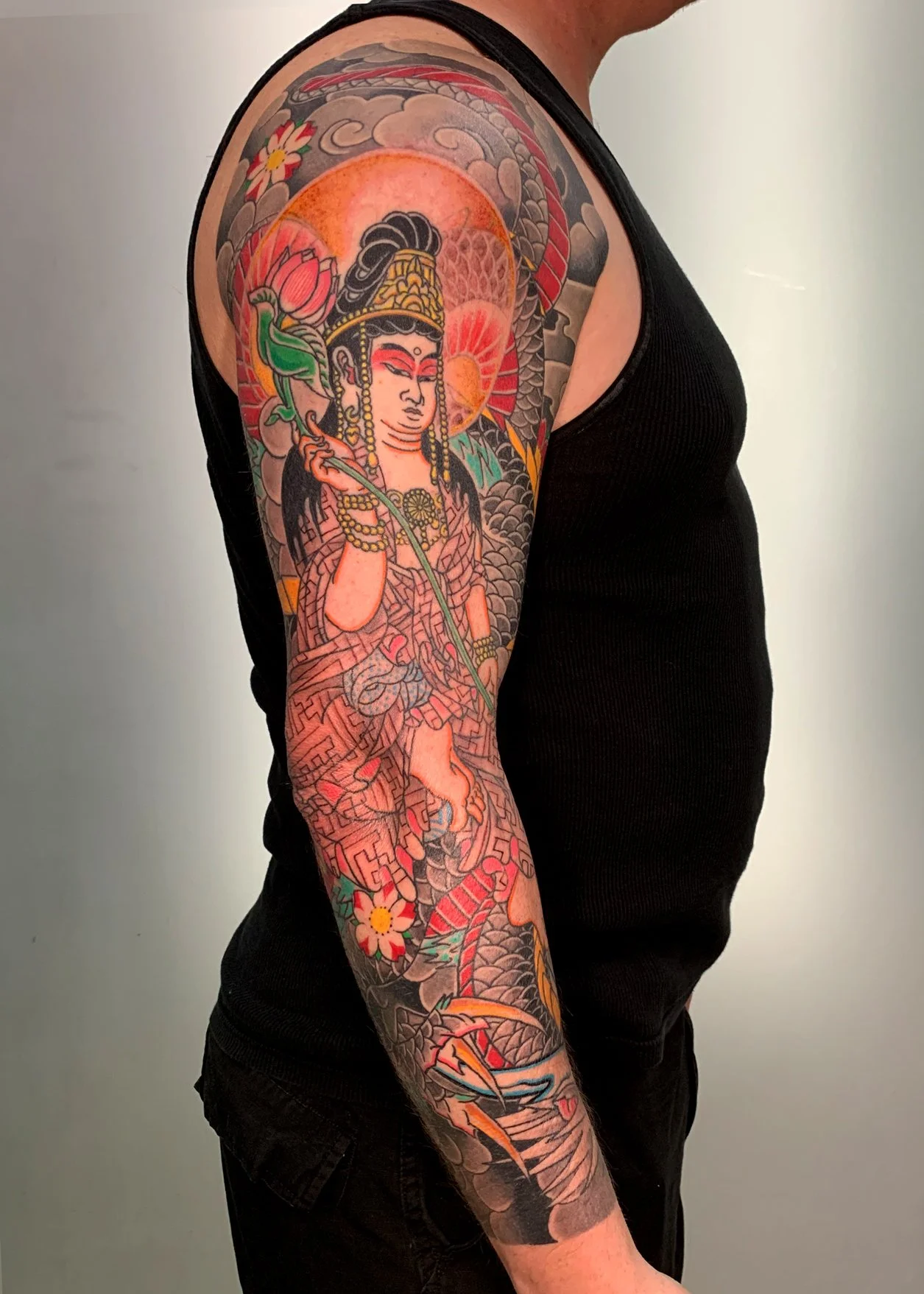 Kannon Bosatsu Japanese Tattoo — Full Sleeve, Fort Lauderdale | A full sleeve featuring Kannon Bosatsu, the Buddhist bodhisattva of compassion, with a dragon, lotus flower, and radiant halo. Entirely machine work. Healed.