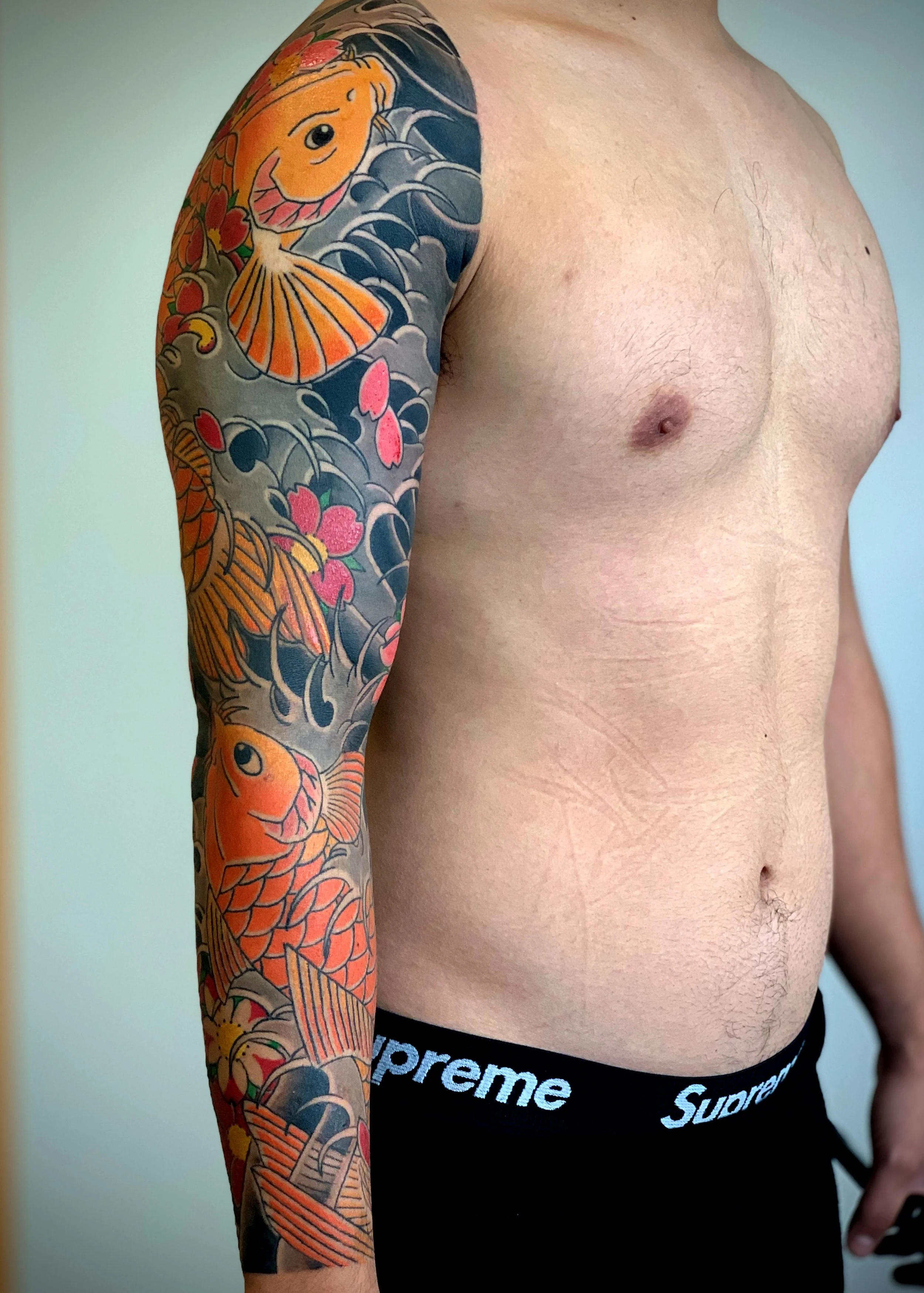 Koi & Cherry Blossom Japanese Tattoo — Full Sleeve, Fort Lauderdale | A full sleeve featuring two koi swimming through water with cherry blossoms. Entirely machine work. Healed.