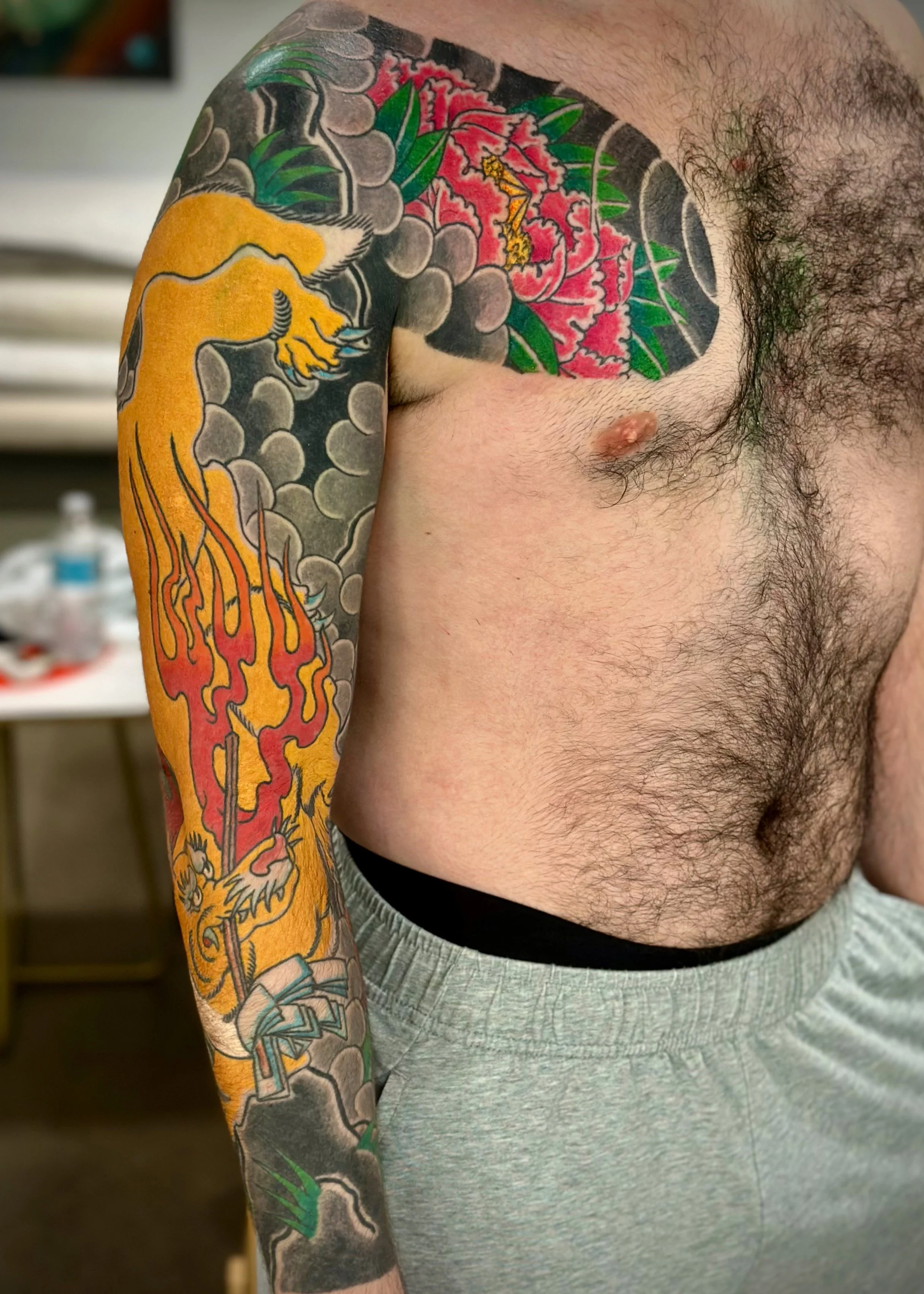 Kitsune (Fox) Japanese Tattoo — Full Sleeve & Chest Panel, Fort Lauderdale | Traditional kitsune (fox) tattoo with cloud and flame background, spanning a full sleeve and chest panel. Outline by machine; all shading and color applied by hand using teb