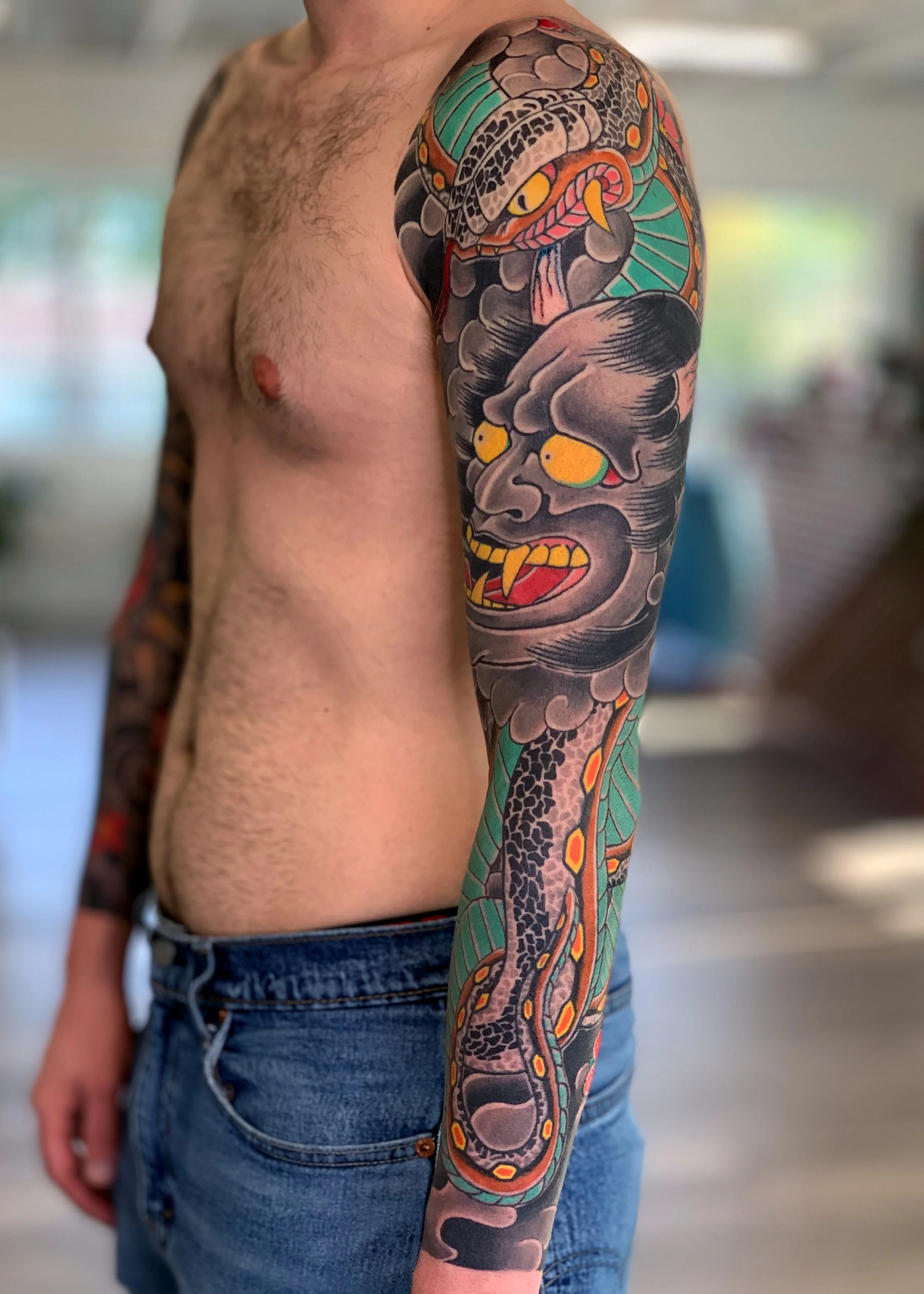 Hannya & Snake Japanese Tattoo — Full Sleeve, Fort Lauderdale | A full sleeve featuring a hannya mask with a teal-green snake coiling above and below. Entirely machine work. Healed.