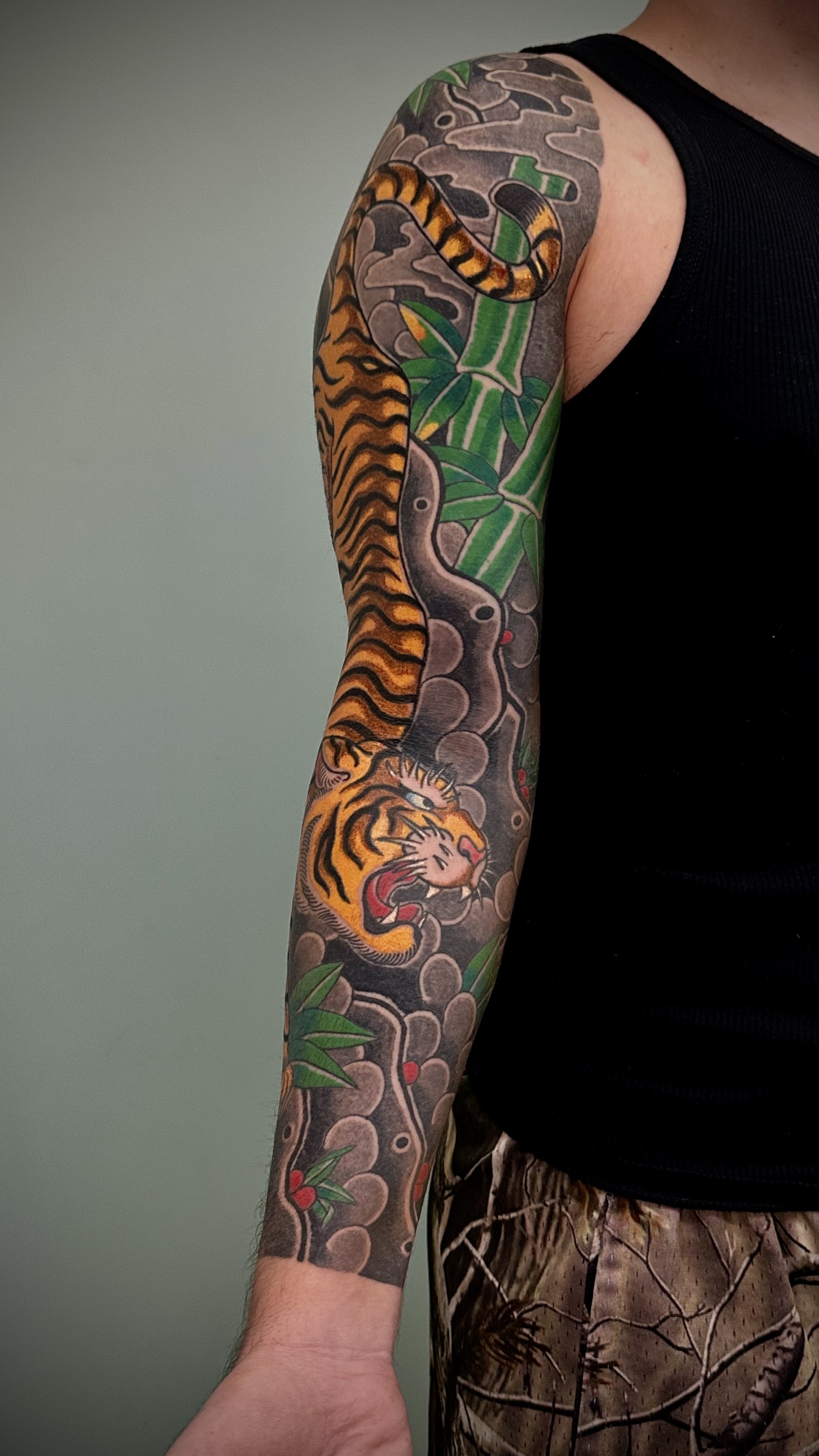Tiger & Bamboo Japanese Tattoo — Full Sleeve, Fort Lauderdale | A full sleeve featuring a tiger descending through bamboo. Outline by machine; all shading and color applied by hand using tebori. Healed.