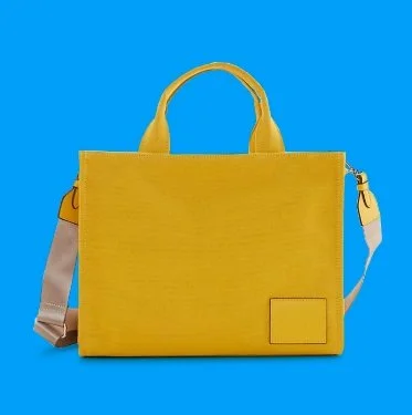 Yellow rectangular handbag with short handles and a detachable shoulder strap against a blue background.