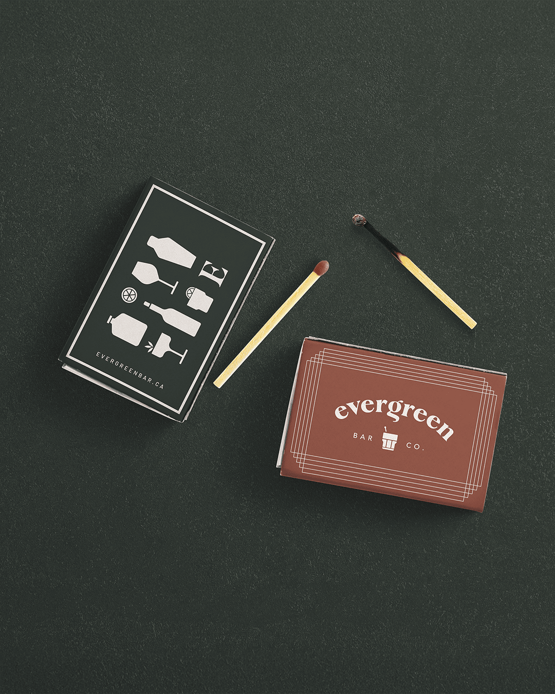 Evergreen Bar Company stationery and matchbooks featuring the logo and illustrated bar icons