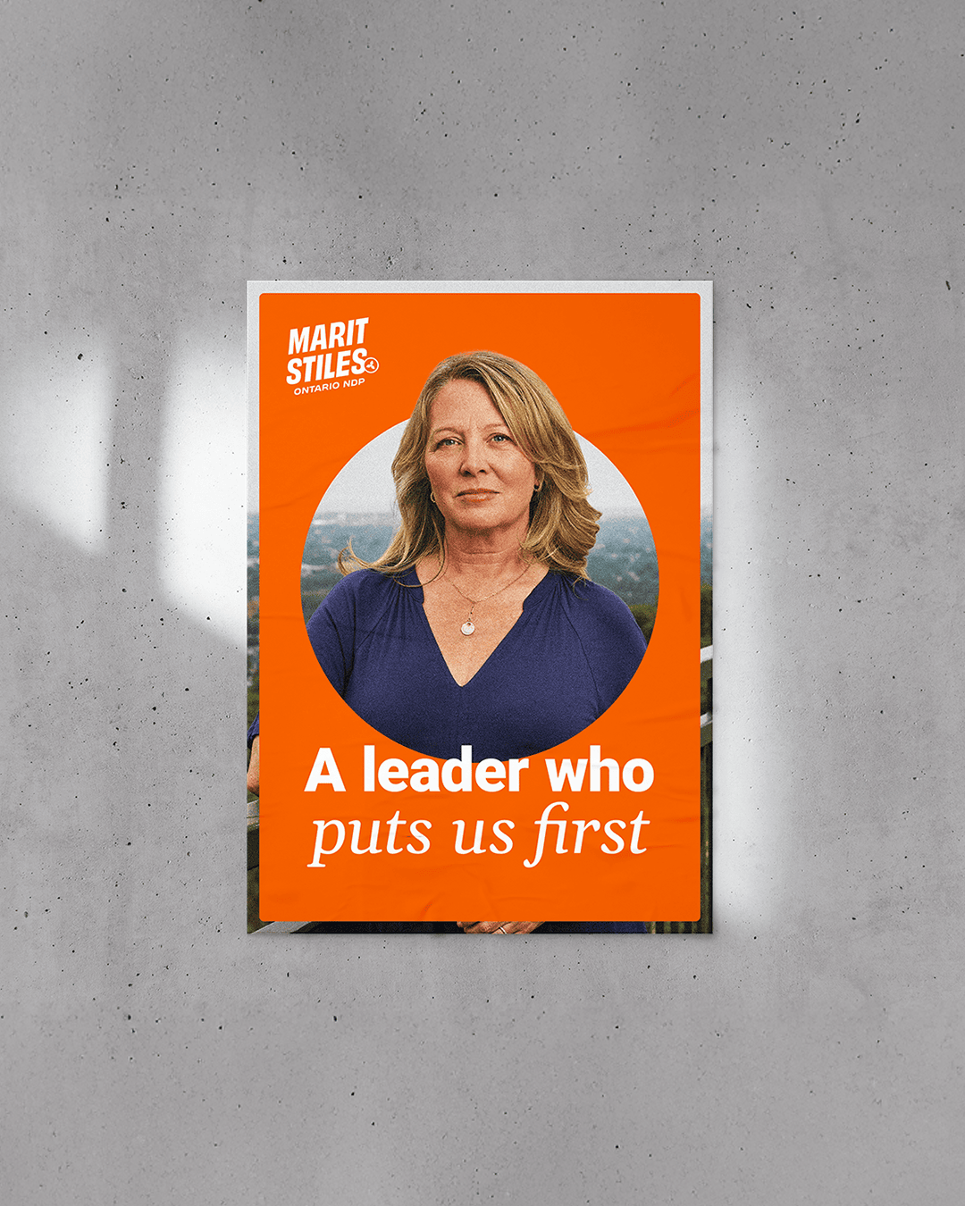 Ontario NDP campaign poster featuring Marit Stiles with the message “A leader who puts us first” on a bright orange background.
