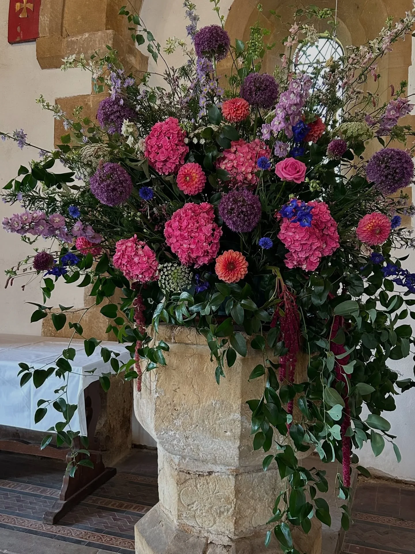 Inside the beautiful Thoresway church we created a huge font arrangement to create a real wow upon entering the church. This was complemented by draping foliage, candles and floral vases. The font arrangement was then carried by two very strong groom