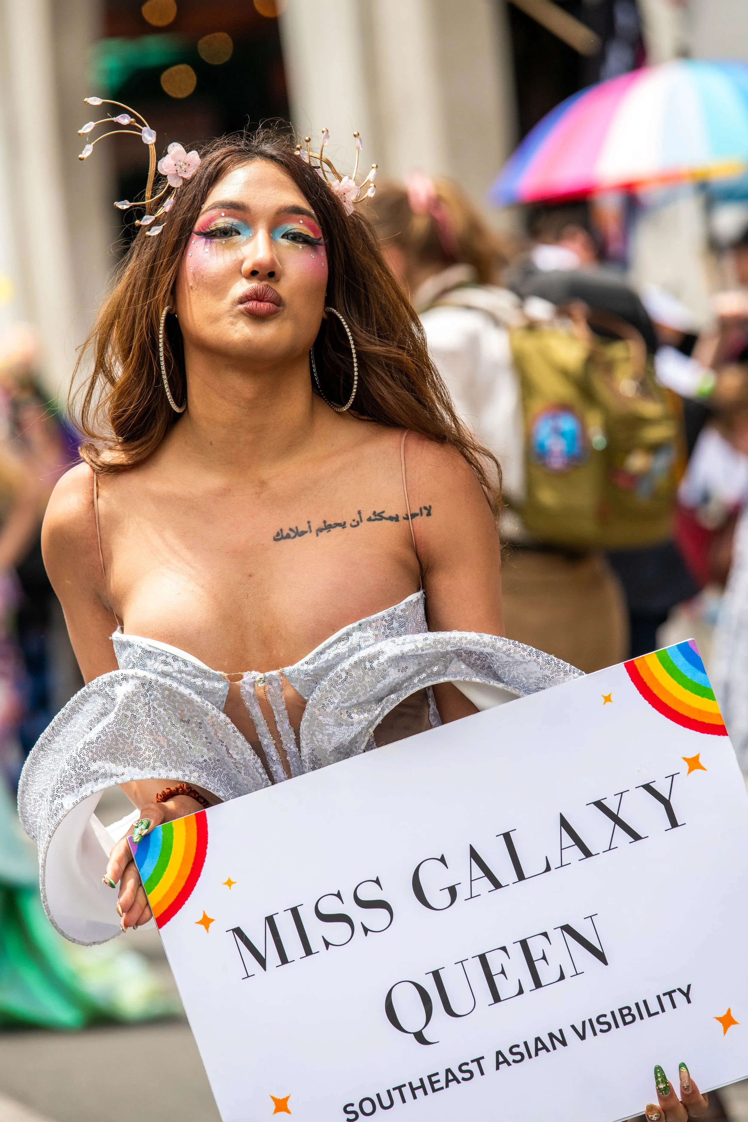 A human in a silver dress blows a kiss at the camera.