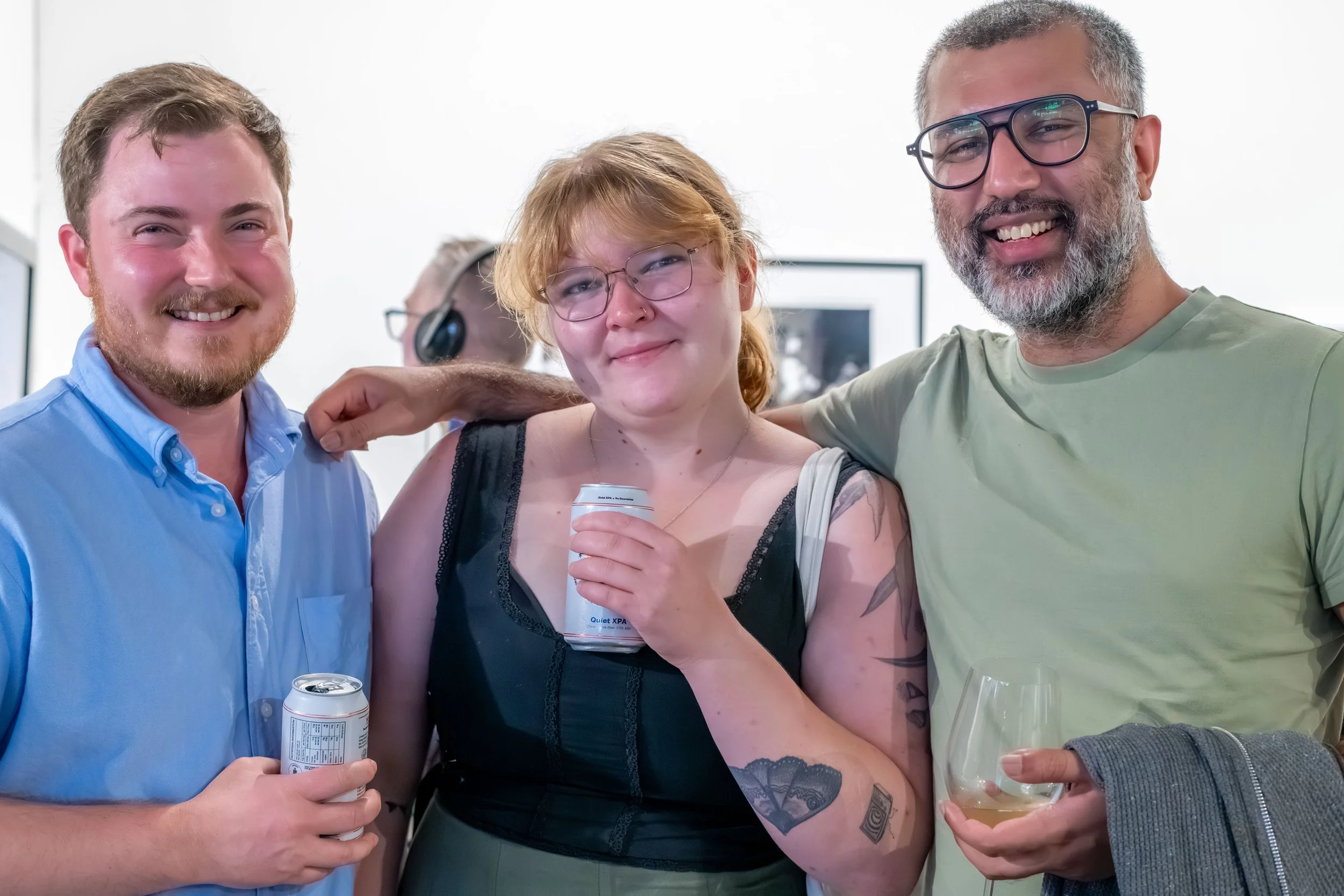 Three humans pose for the camera.