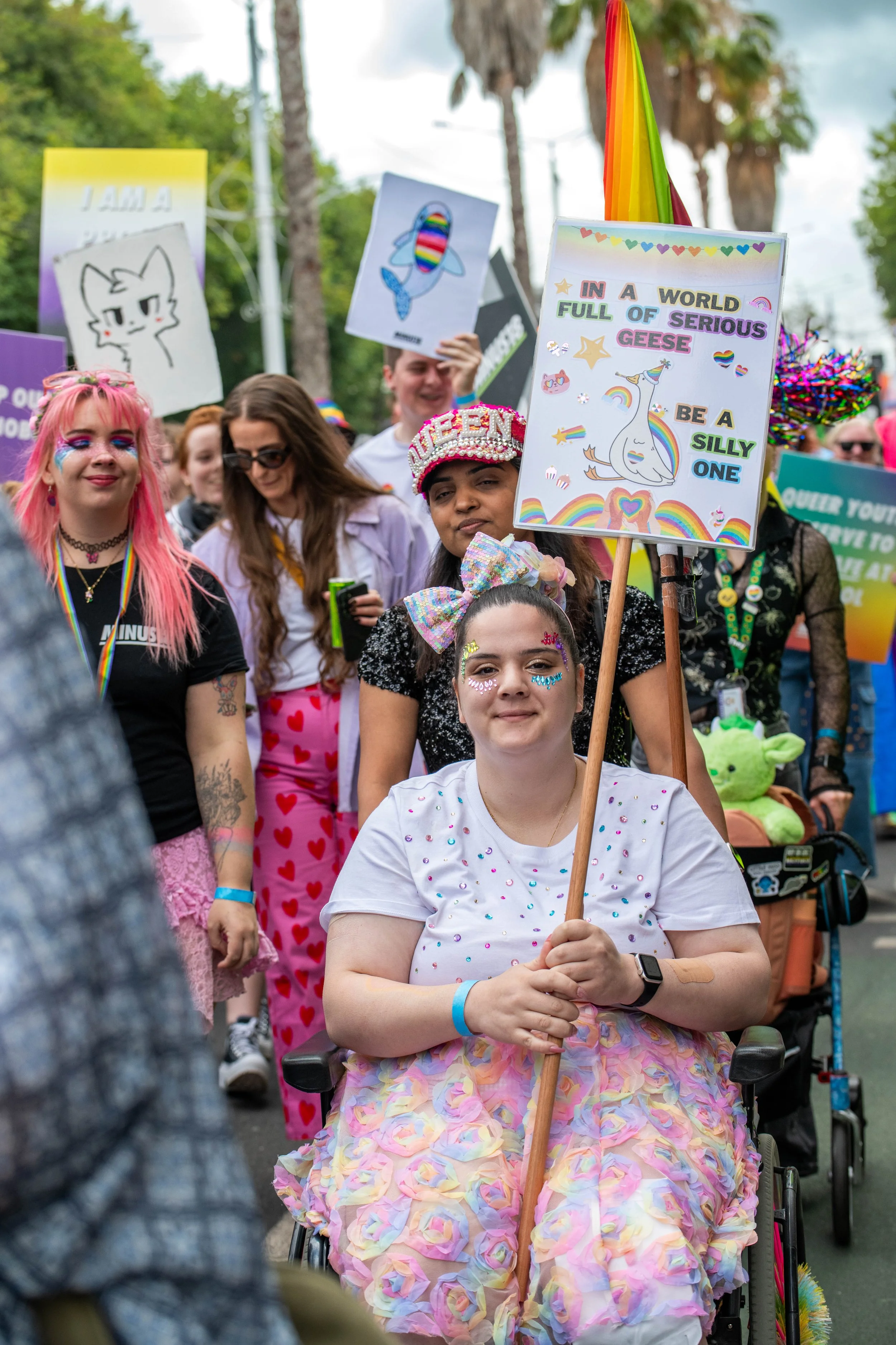 A human in a wheelchair holding a sign.