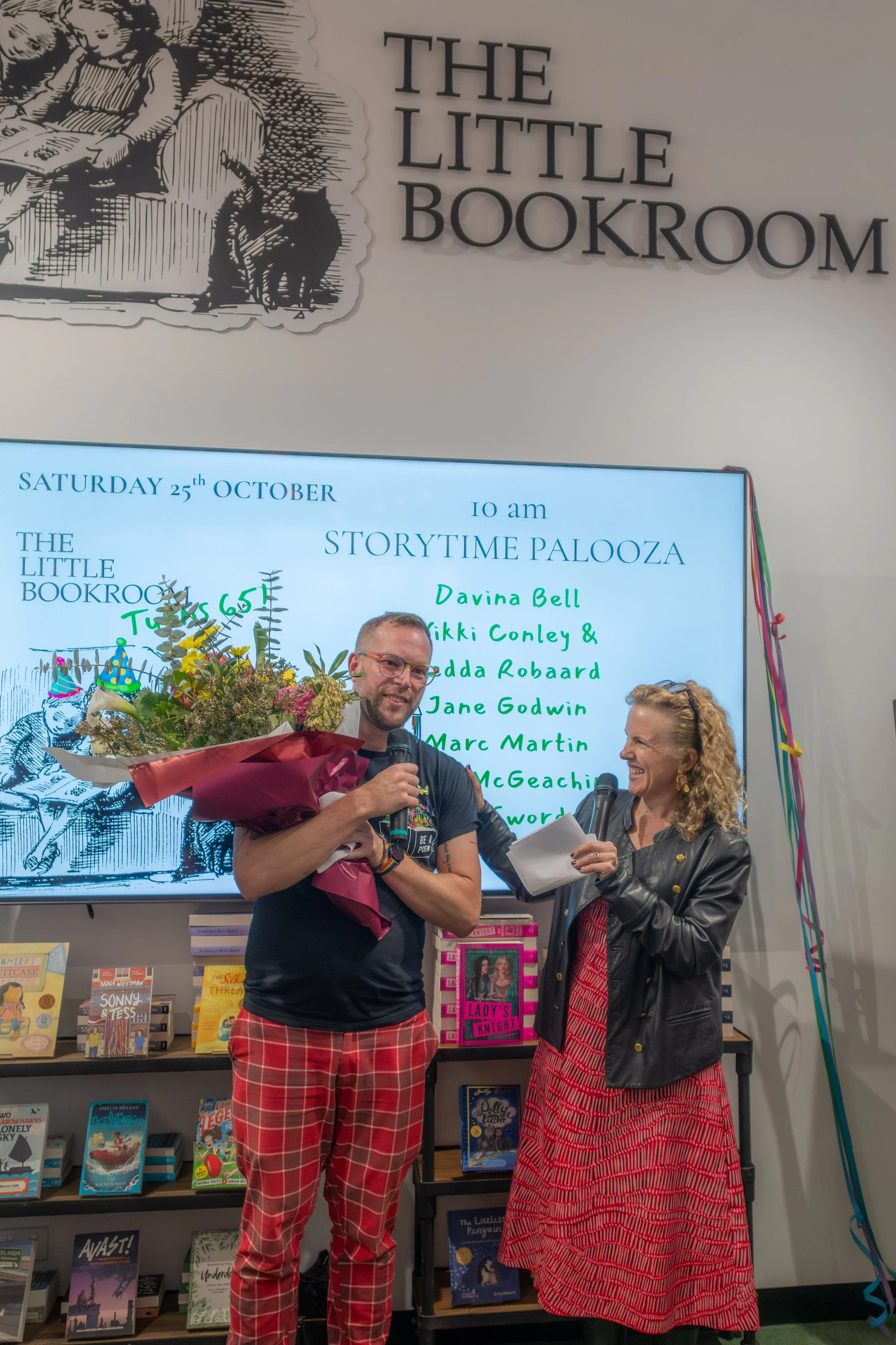 Michael Earp holds a large bouquet of flowers as Sally Rippin interviews them.