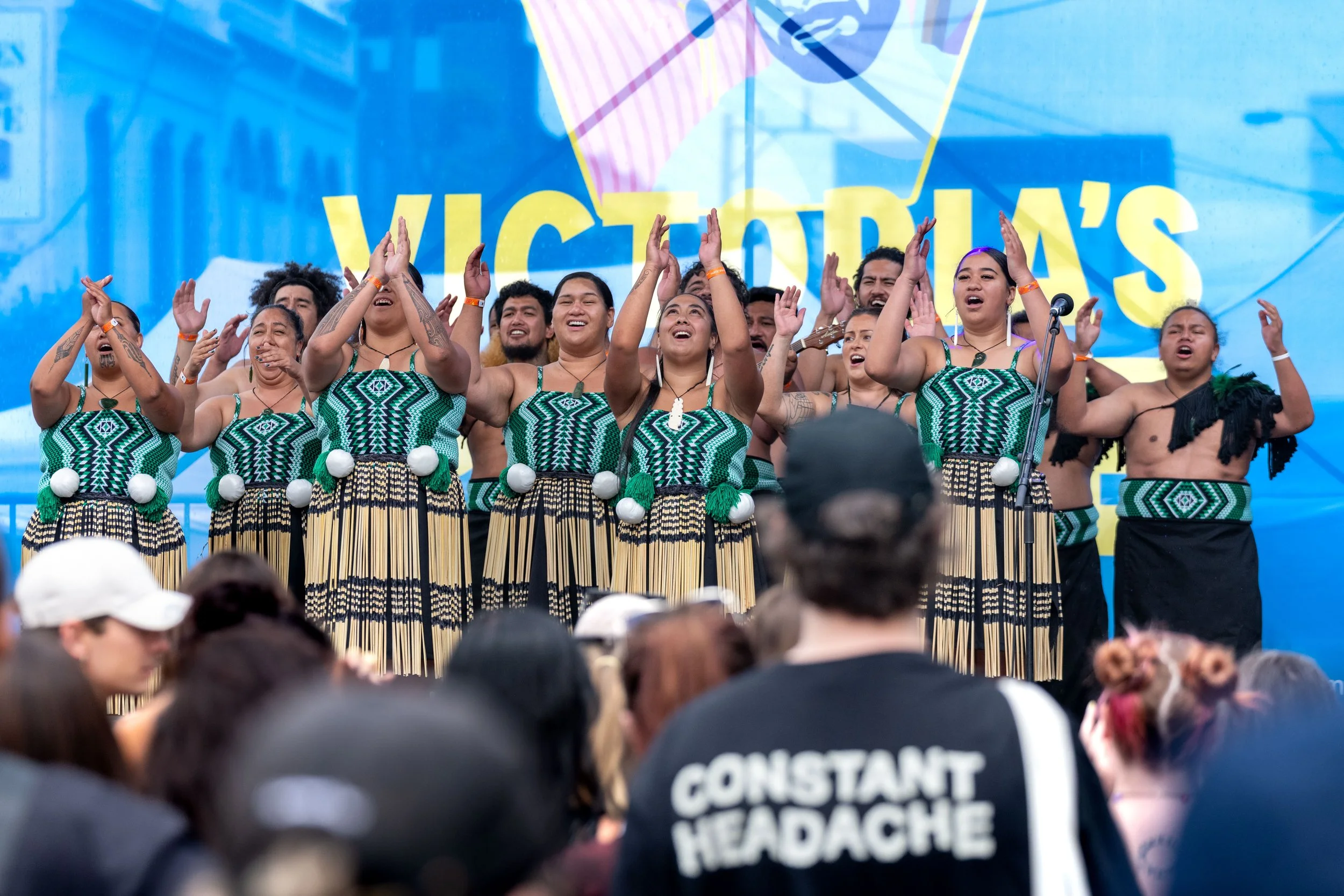 Many dancers from the Pacifique X Fiafia Pride Celebration as a crowd watches on.