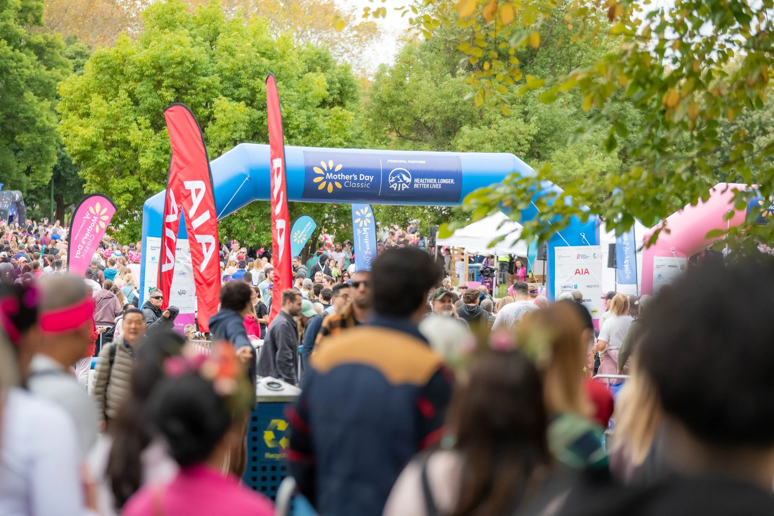 The finish line can be seen across the heads of many racegoers.