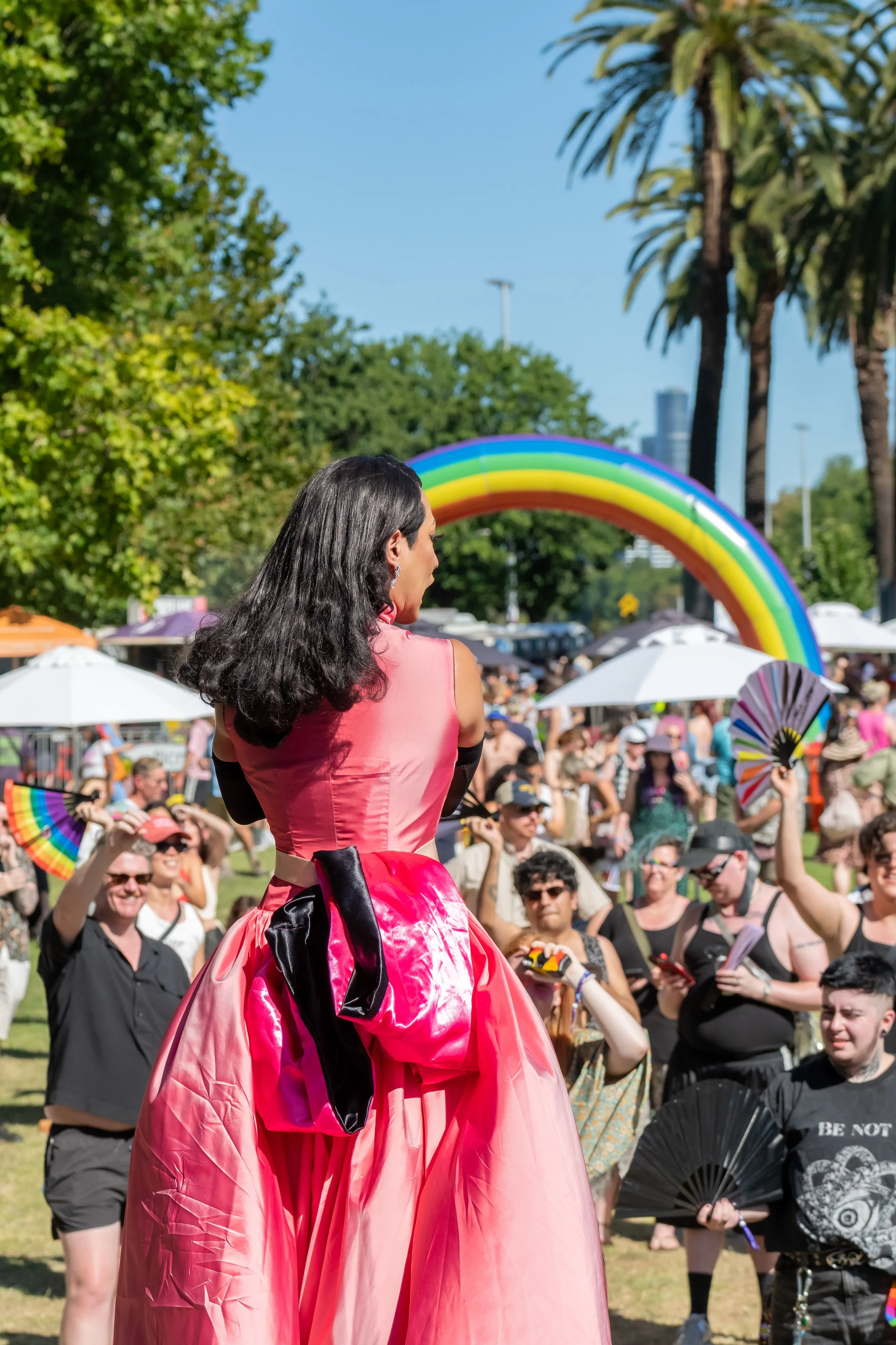 So Hung Son dances toward the crowd. A large inflatable rainbow is in the background.