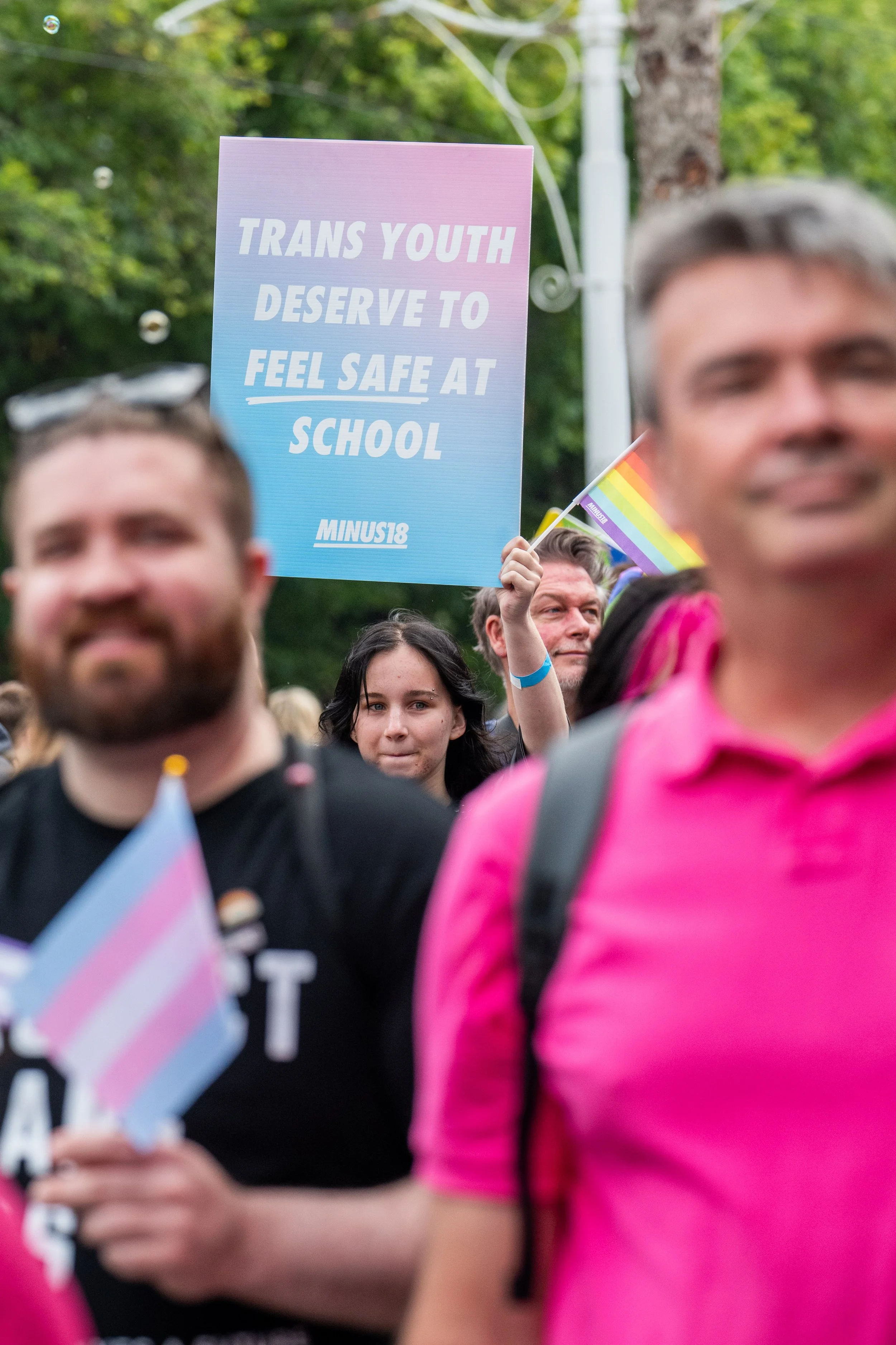 A placard "Trans youth deserve to feel safe at school".