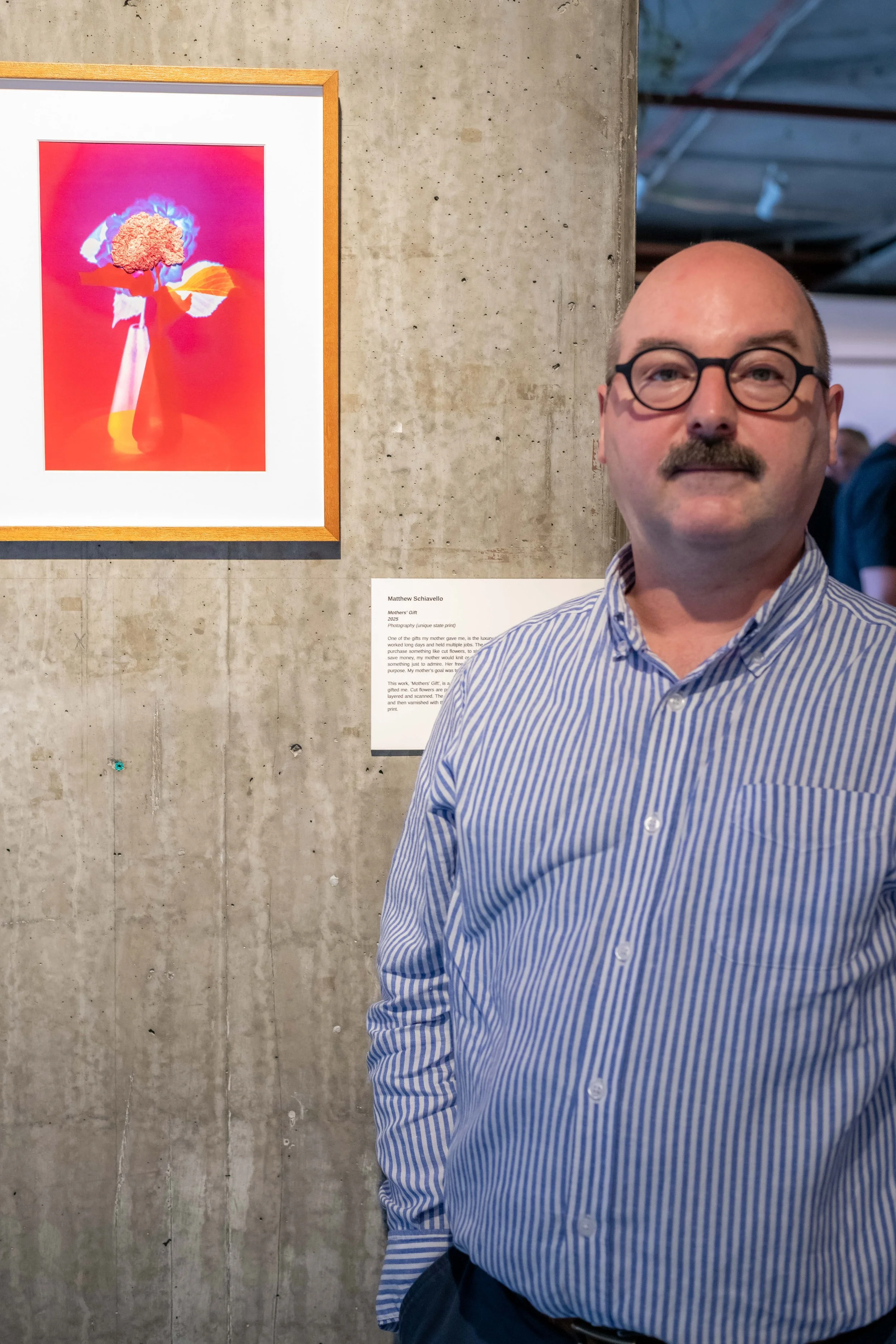 An artist poses with their artwork.