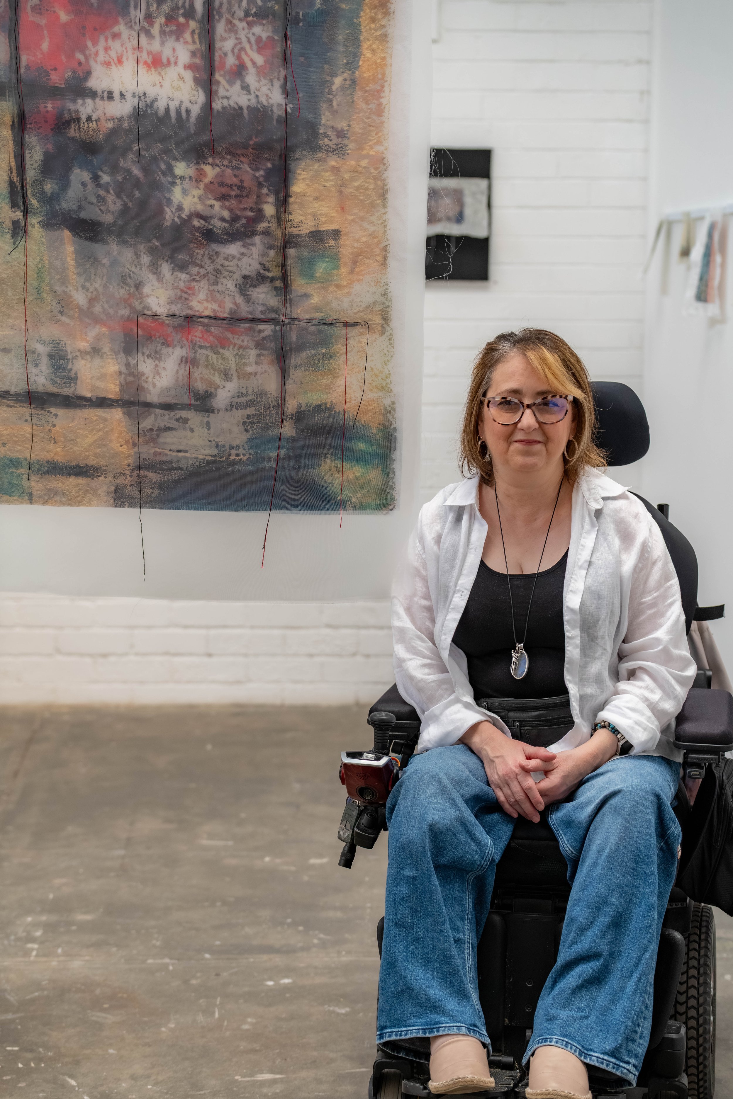 Helen Henwood next to one of their tapestry paintings.
