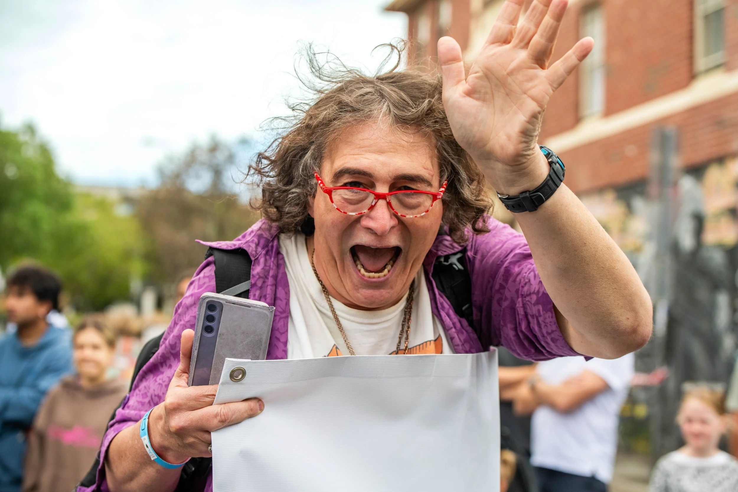 A human waves at the camera with their mouth open.