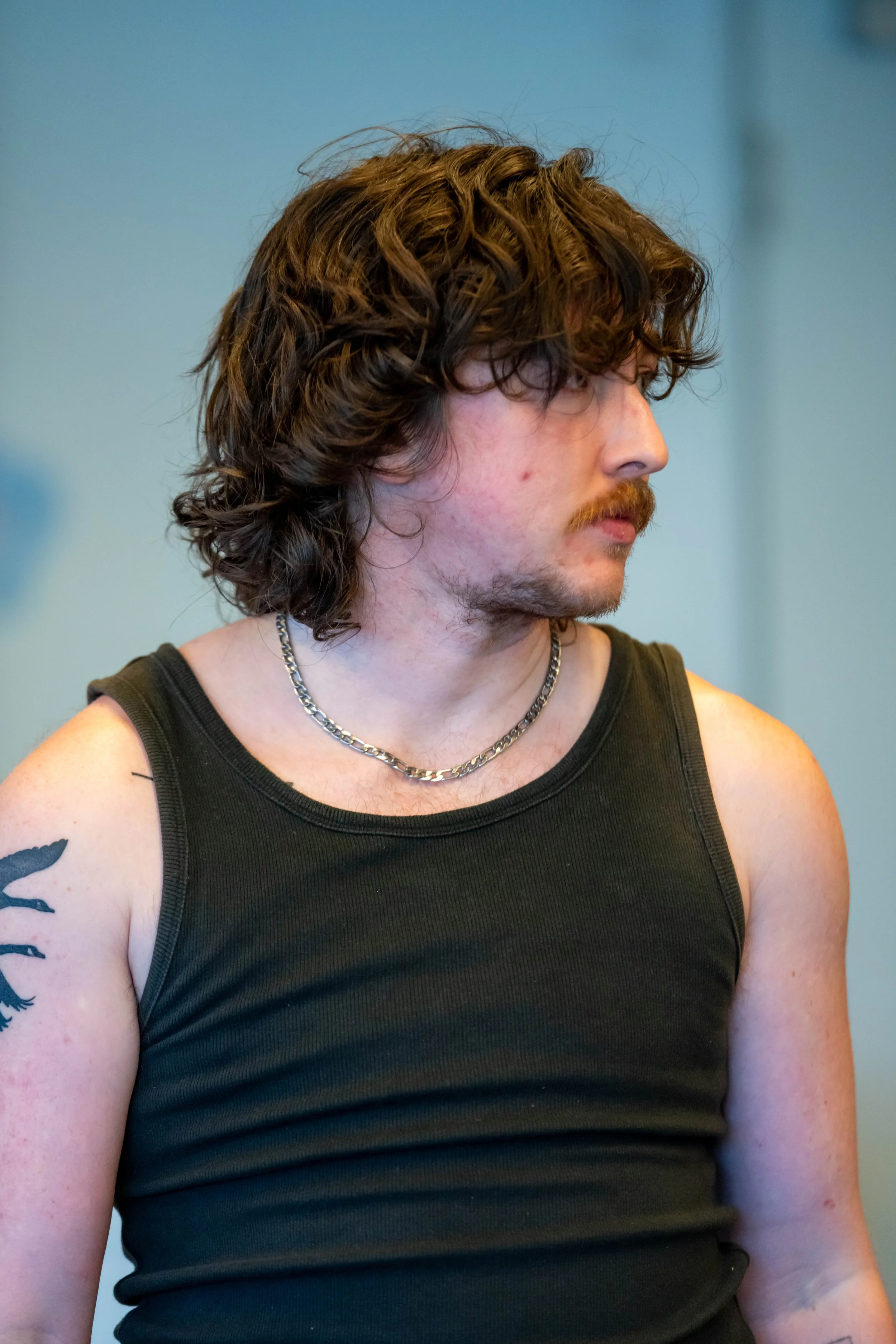 A human in a black singlet looks to the side.