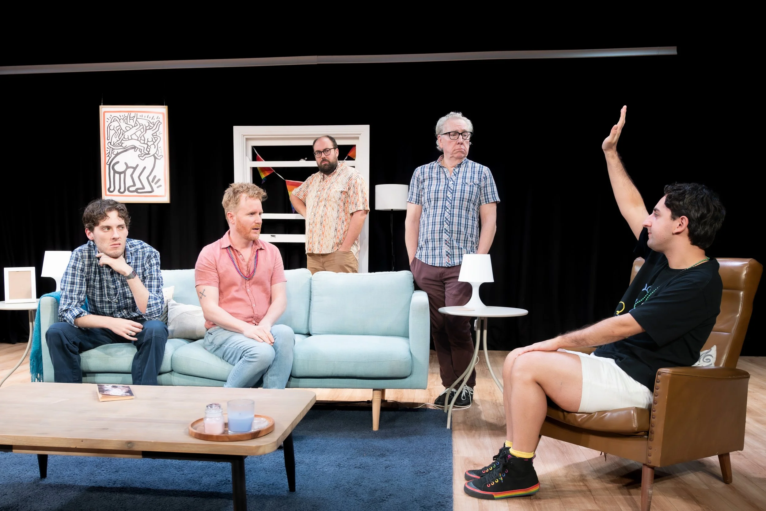 A human raises their hand as four others look on.