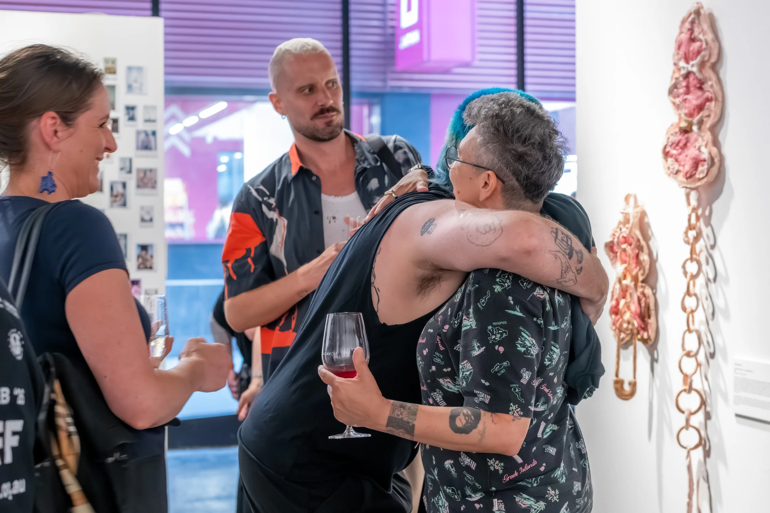 Two people hug as others look on.