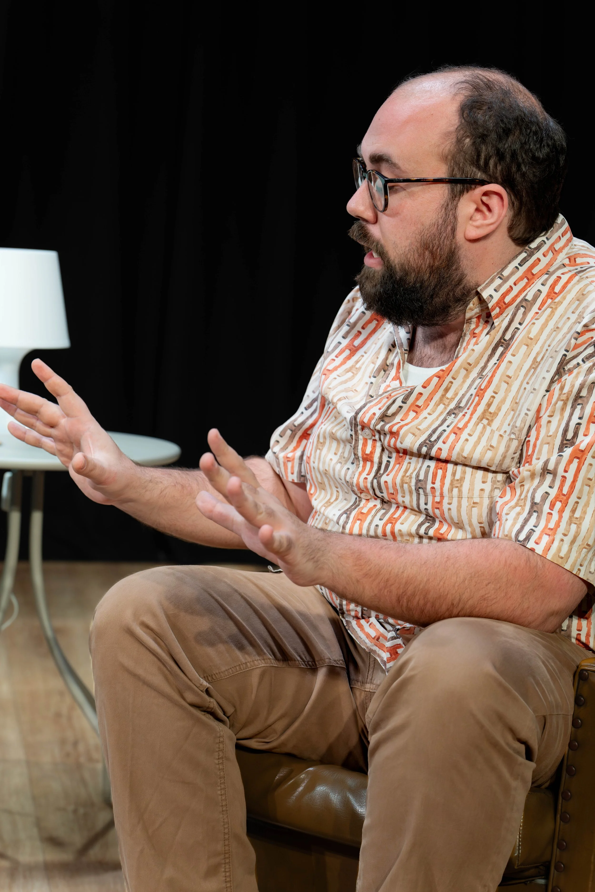 A human sits and gesticulates.