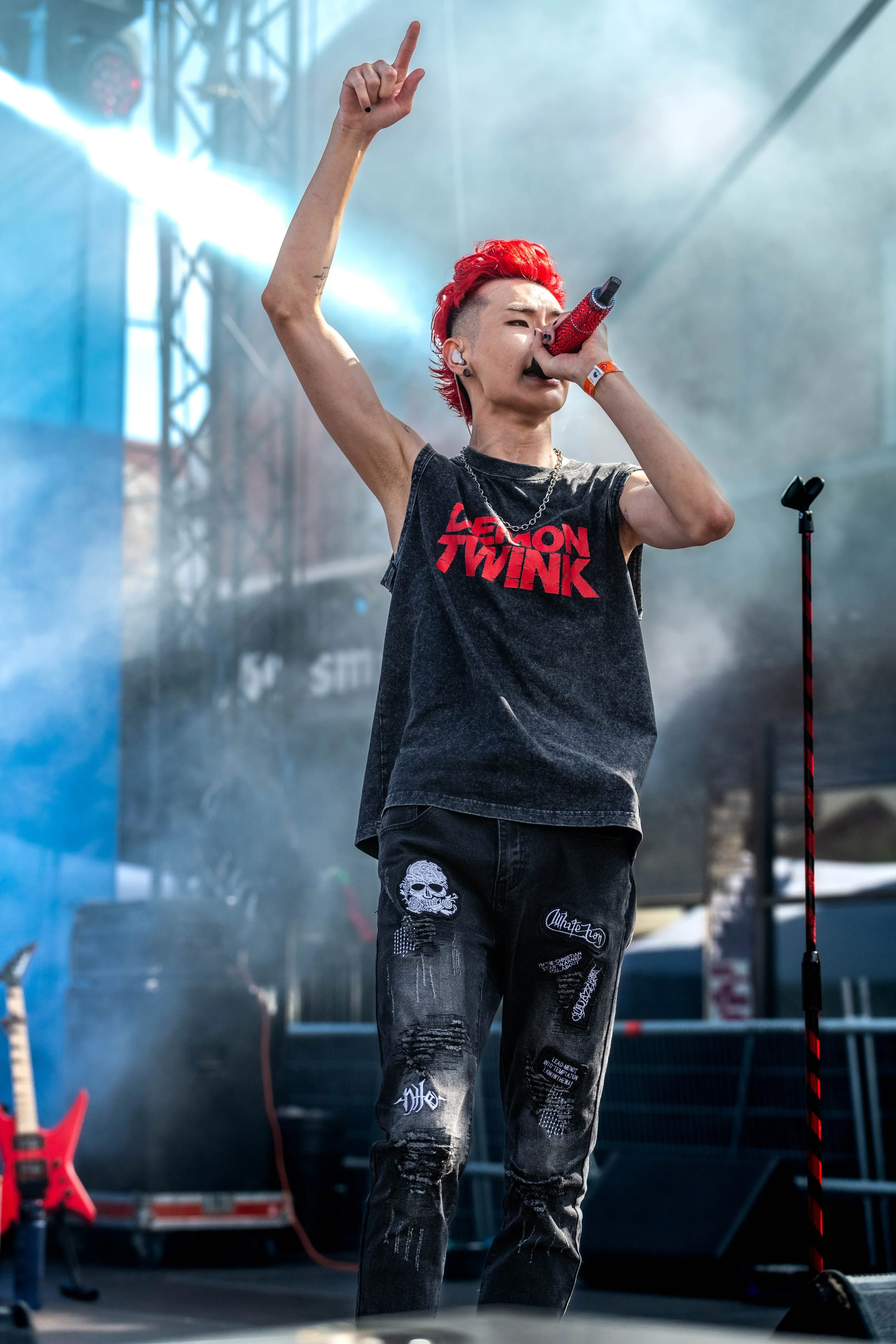 Kevin Silvester sings into a microphone and holds a finger up into the air.