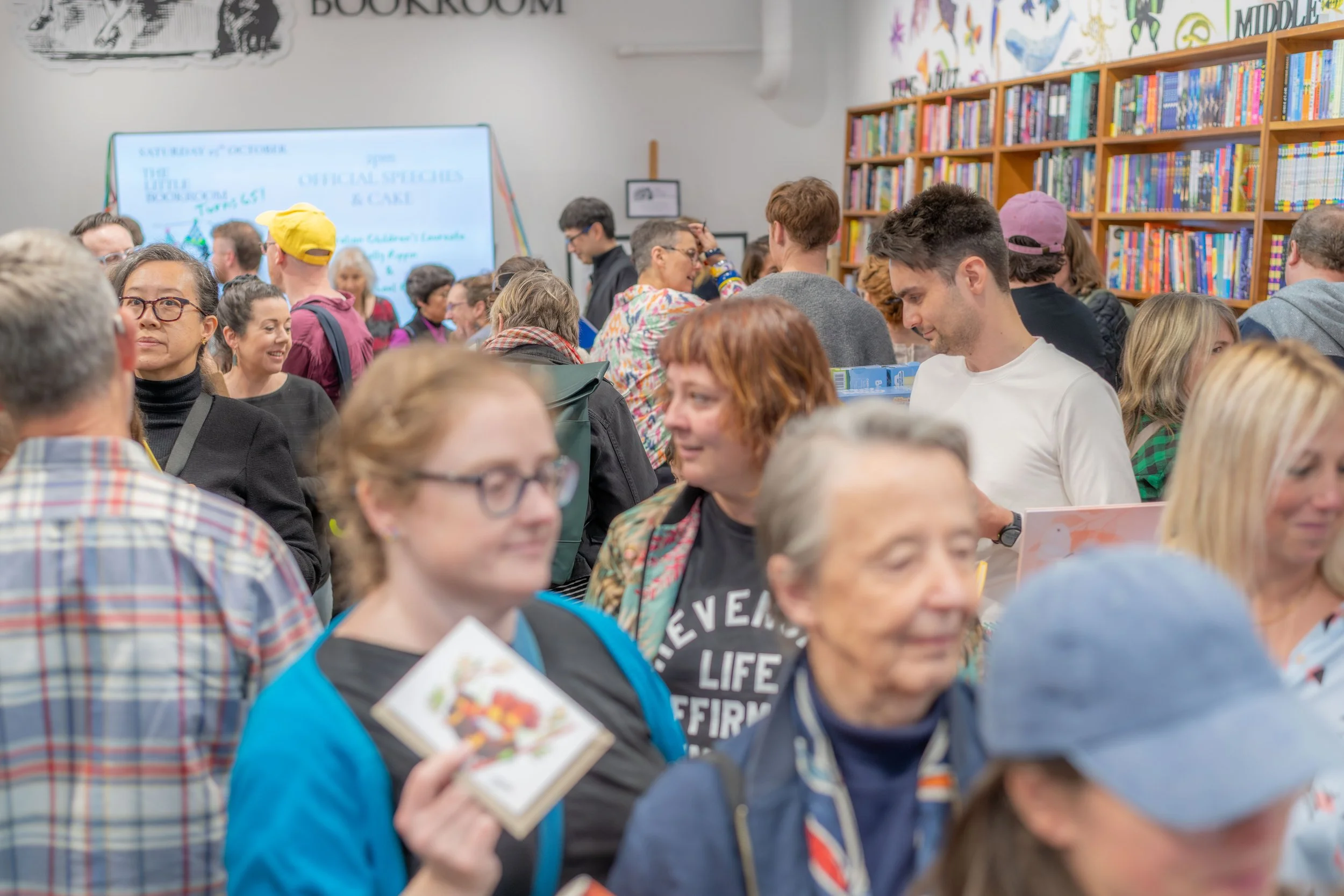Large masses of humans chat throughout the bookstore.