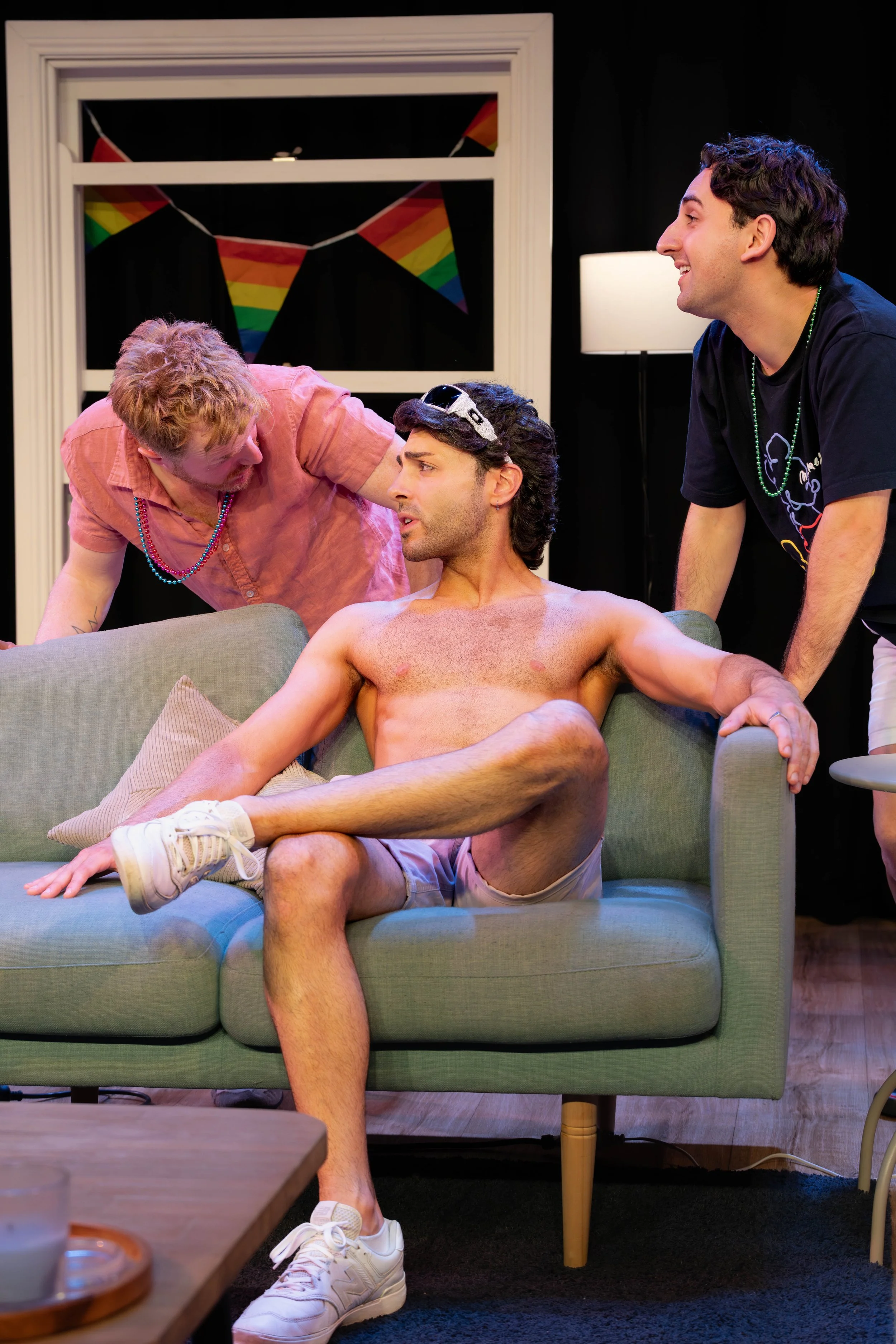 Two humans lean over a shirtless human.