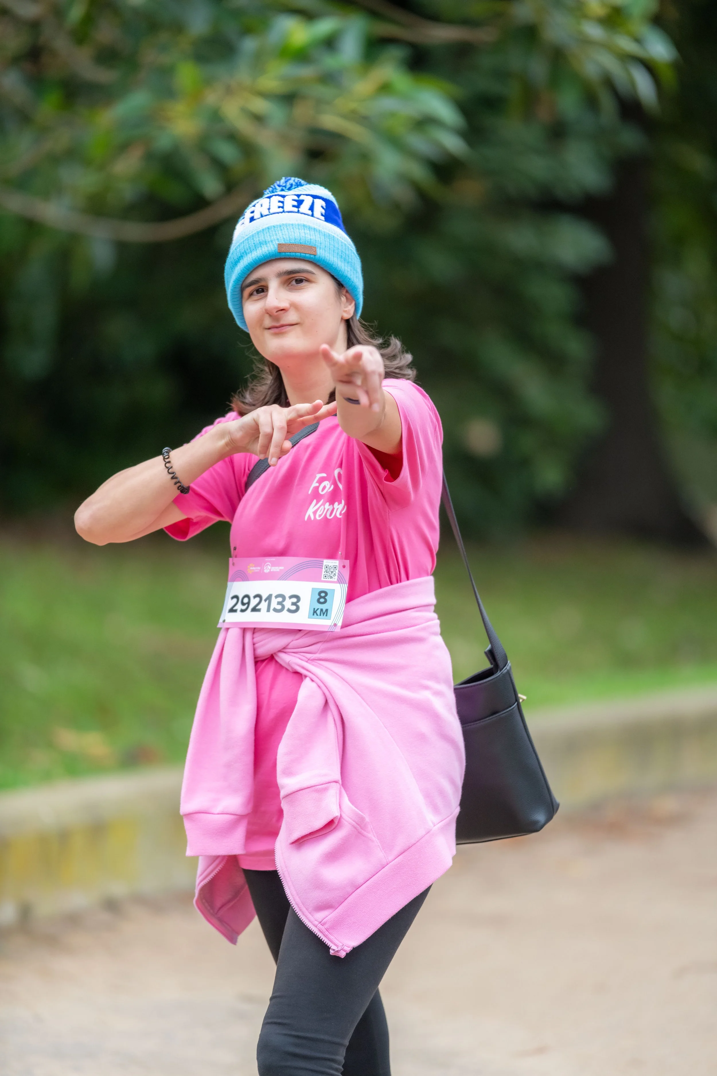 A racegoer in pink points at the camera.
