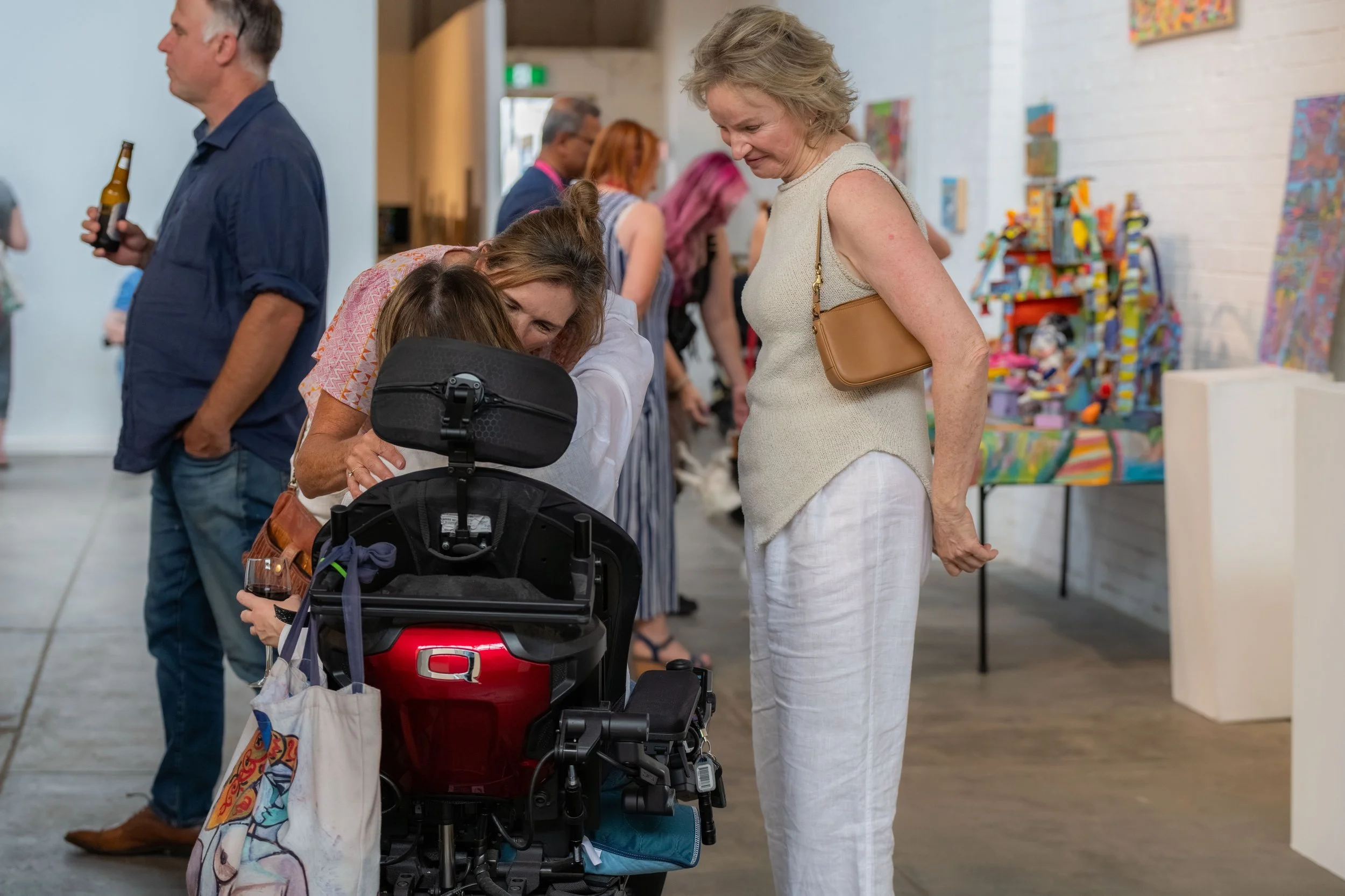 A human in a wheelchair hugs a standing human.