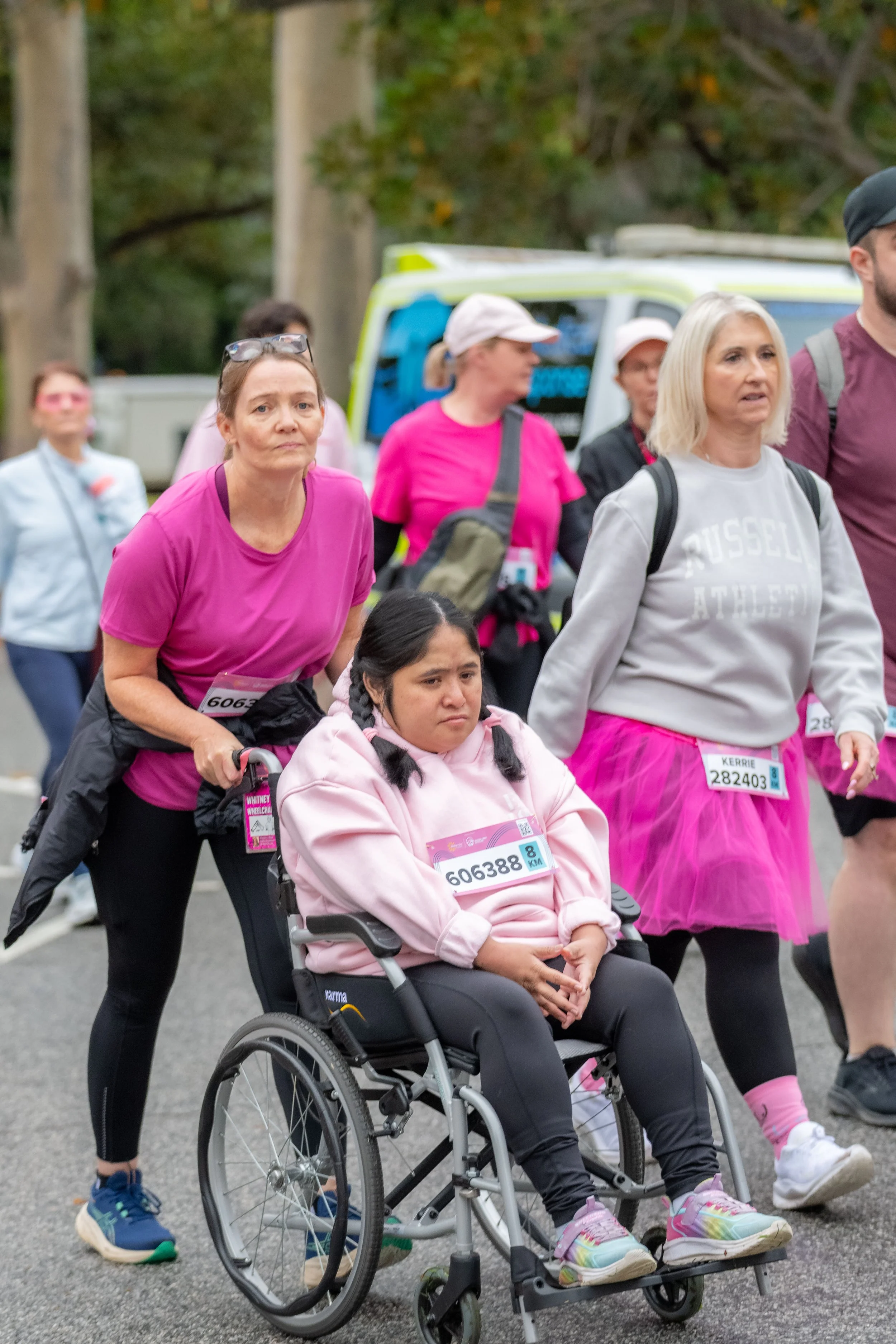A racegoer being pushed in a wheelchair.