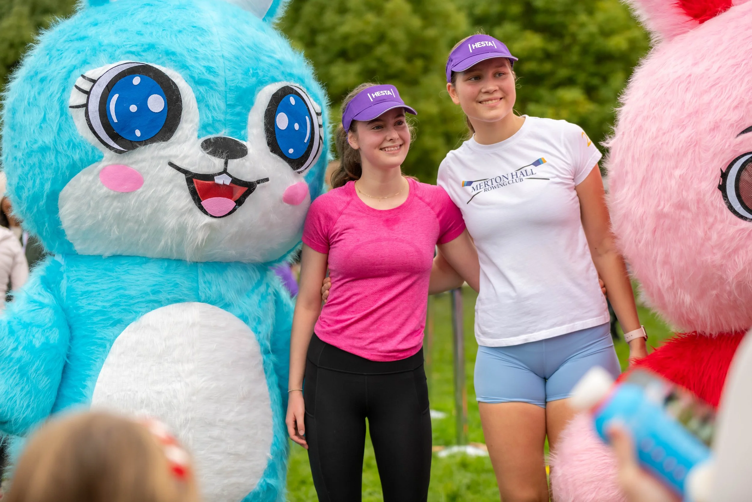 Two young racegoers pose with large labubus.